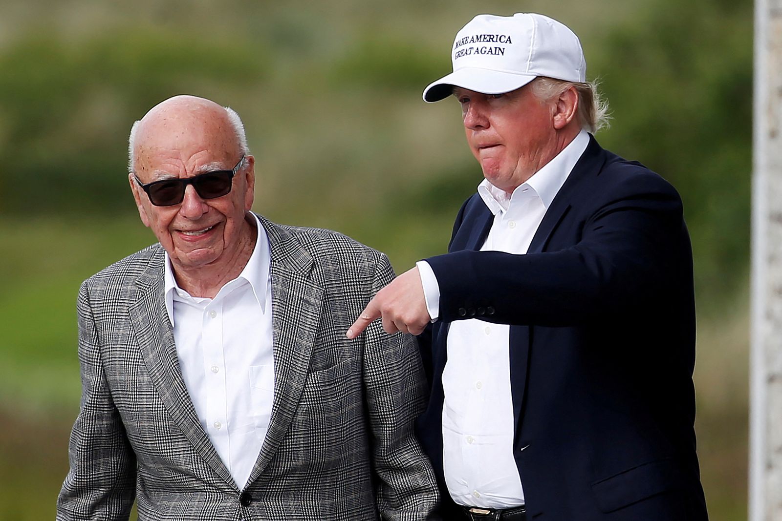 FILE PHOTO: Republican presidential candidate Donald Trump speaks to media mogul Rupert Murdoch as they walk out of Trump International Golf Links in Aberdeen - REUTERS