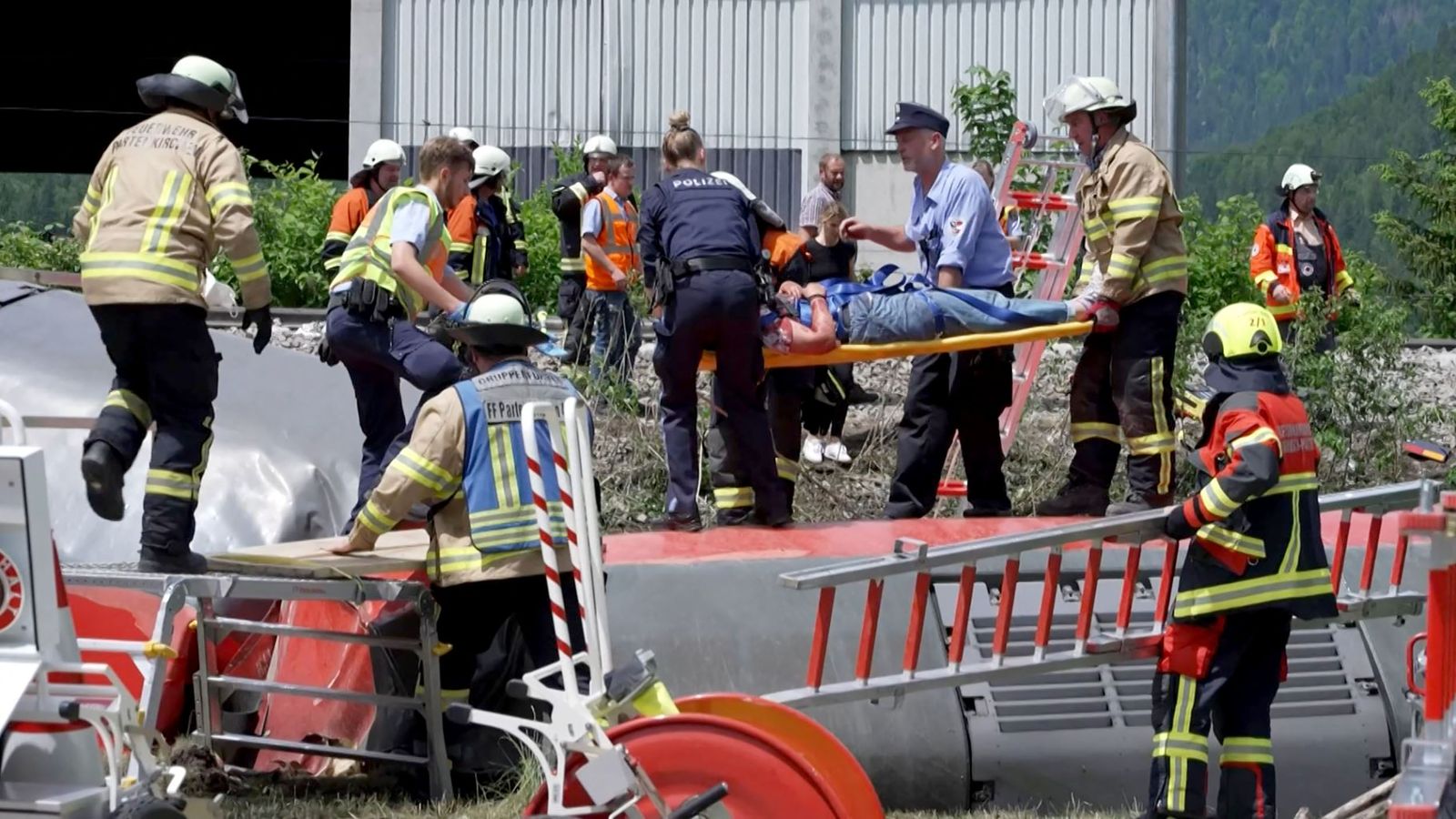 This video grab shows policemen and firemen rescuing a person from a derailed train on June 3, 2022 in Burgrain near Garmisch-Partenkirchen, southern Germany. - At least three people were killed and several others injured as a train derailed near a Bavarian Alpine resort in southern Germany, police said. (Photo by Mathias HEINE / NETWORK PICTURES / AFP) - AFP