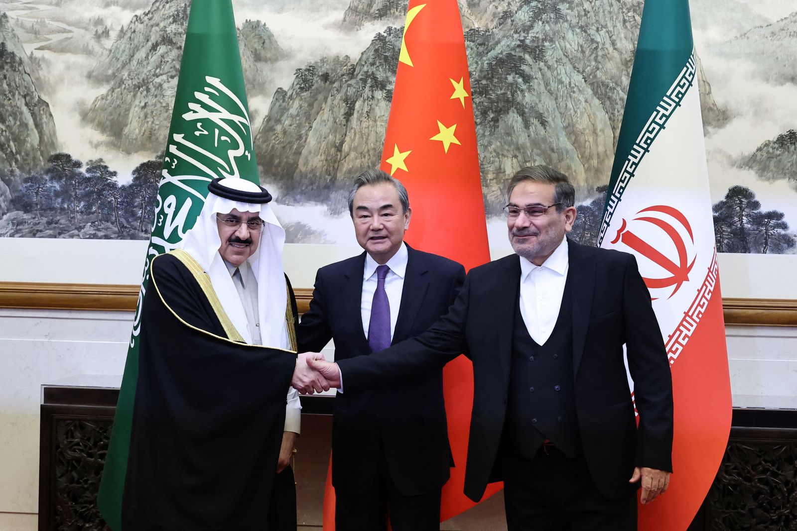 كبير الدبلوماسيين الصينيين وانج يي يتوسط مستشار الأمن الوطني السعودي مساعد العيبان وأمين المجلس الأعلى للأمن القومي الإيراني علي شمخاني خلال توقيع الاتفاق السعودي الإيراني في بكين، 10 مارس 2023