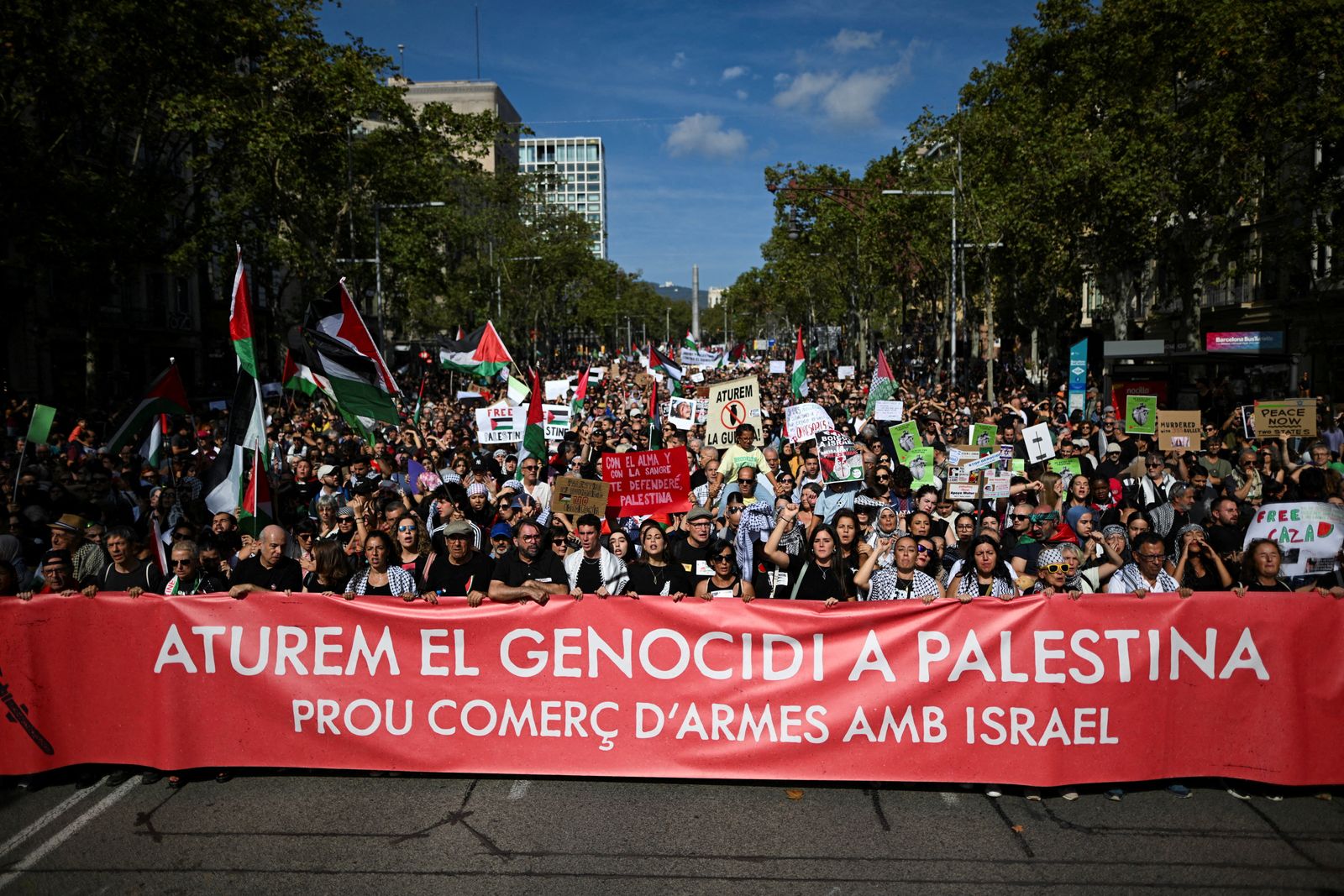 People hold a banner during a pro-Palestinian protest, and to condemn the Israeli forces' interception of the Global Sumud Flotilla vessels which were aiming to reach Gaza and break Israel's naval blockade, in Barcelona, Spain, October 4, 2025. The banner reads 'Stop the genocide in Palestine. No more arms trade with Israel'. REUTERS/Lorena Sopena