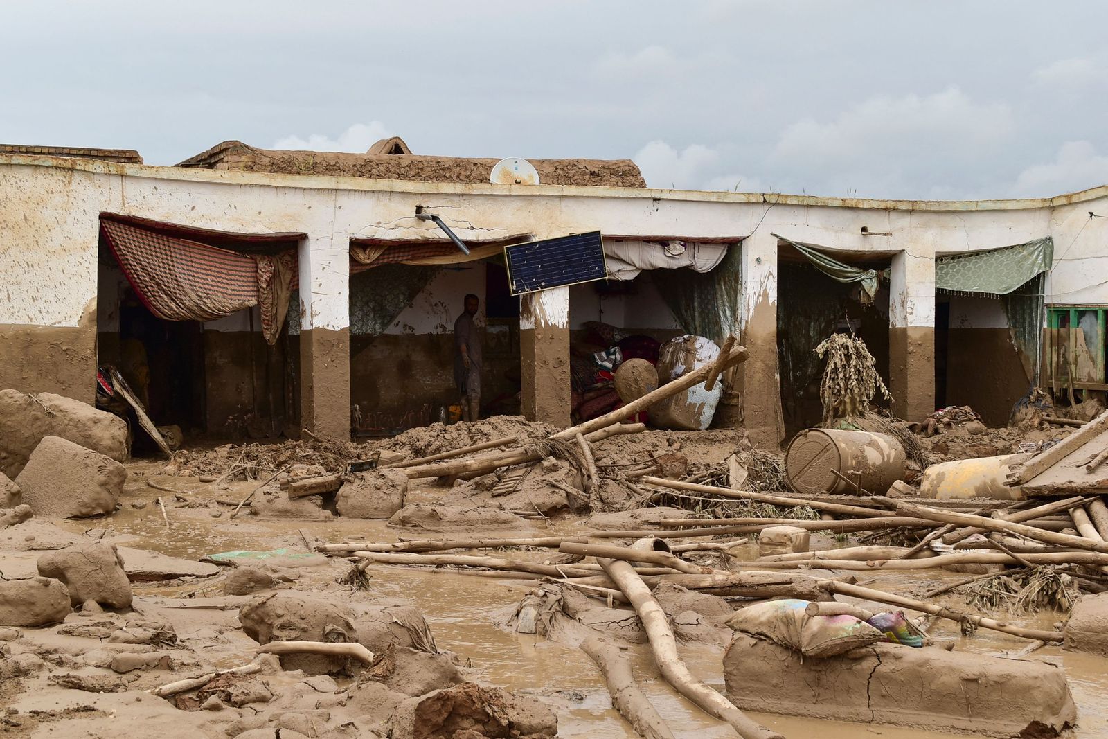 Afghan men clear debris and mud from a damaged house following a flash flood after a heavy rainfall in Laqiha village of Baghlan-i-Markazi district in Baghlan province on May 11, 2024. At least 62 people, mainly women and children, were killed on May 10 in flash flooding that ripped through Afghanistan's Baghlan province, in the north of the country, a local official told AFP. (Photo by AFP)