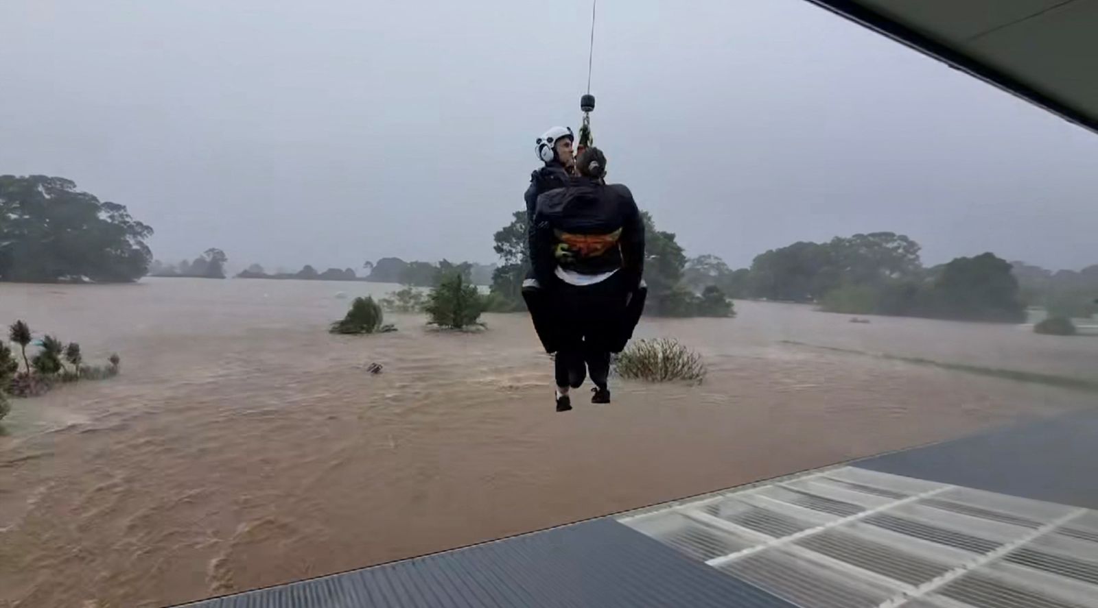 NSW Police use a helicopter to rescue a resident from their rooftop from floodwaters in Taree, New South Wales, Australia, May 21, 2025, in this screen grab obatined from a video.  AAP/Sam Halloran/via REUTERS    ATTENTION EDITORS - THIS IMAGE WAS PROVIDED BY A THIRD PARTY. NO RESALES. NO ARCHIVE. AUSTRALIA OUT. NEW ZEALAND OUT. NO COMMERCIAL OR EDITORIAL SALES IN NEW ZEALAND. NO COMMERCIAL OR EDITORIAL SALES IN AUSTRALIA.