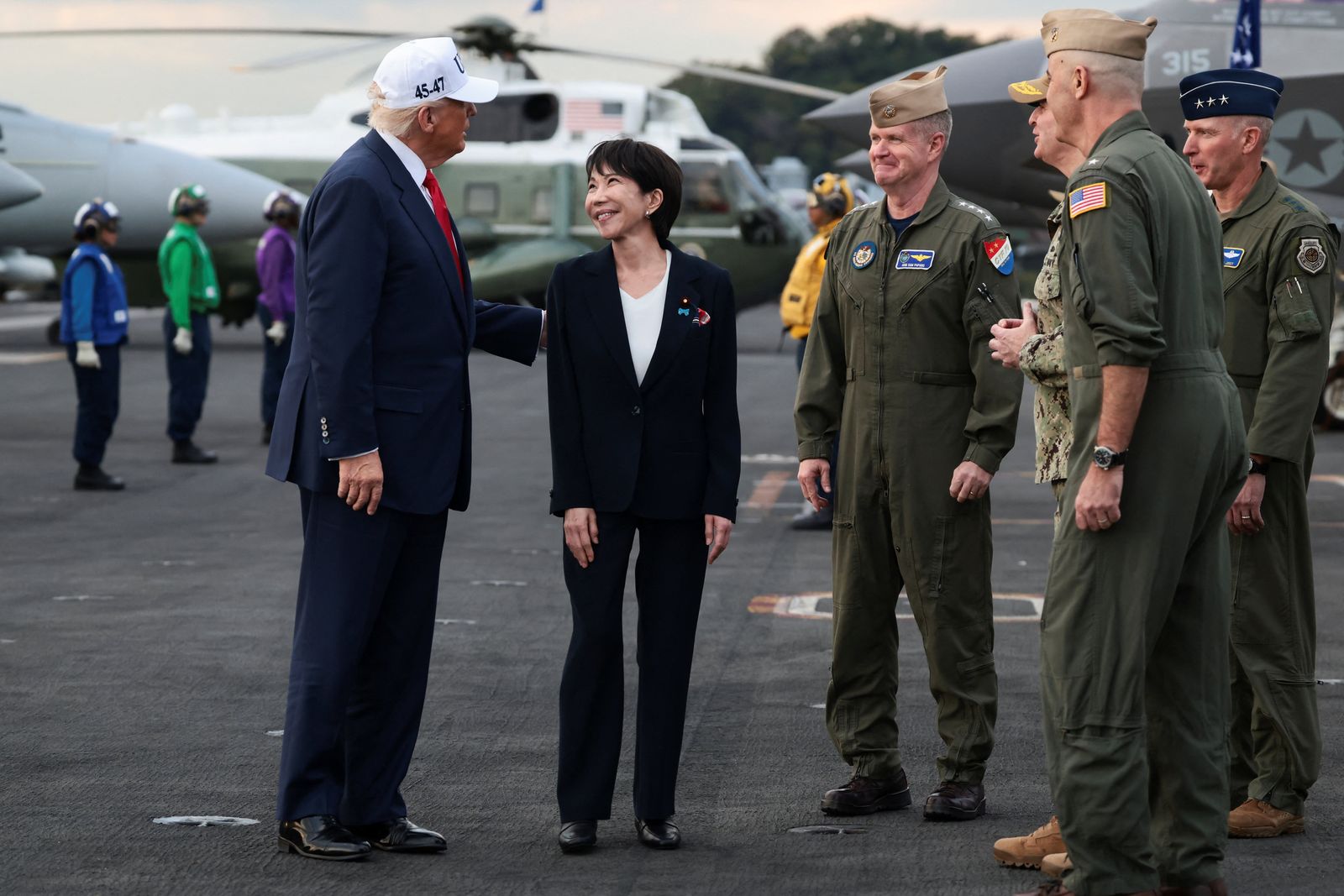 U.S. President Donald Trump and Japanese Prime Minister Sanae Takaichi are welcomed by U.S. Navy sailors, aboard the aircraft carrier USS George Washington, during a visit to U.S. Navy's Yokosuka base in Yokosuka, Japan, October 28, 2025. REUTERS/Evelyn Hockstein