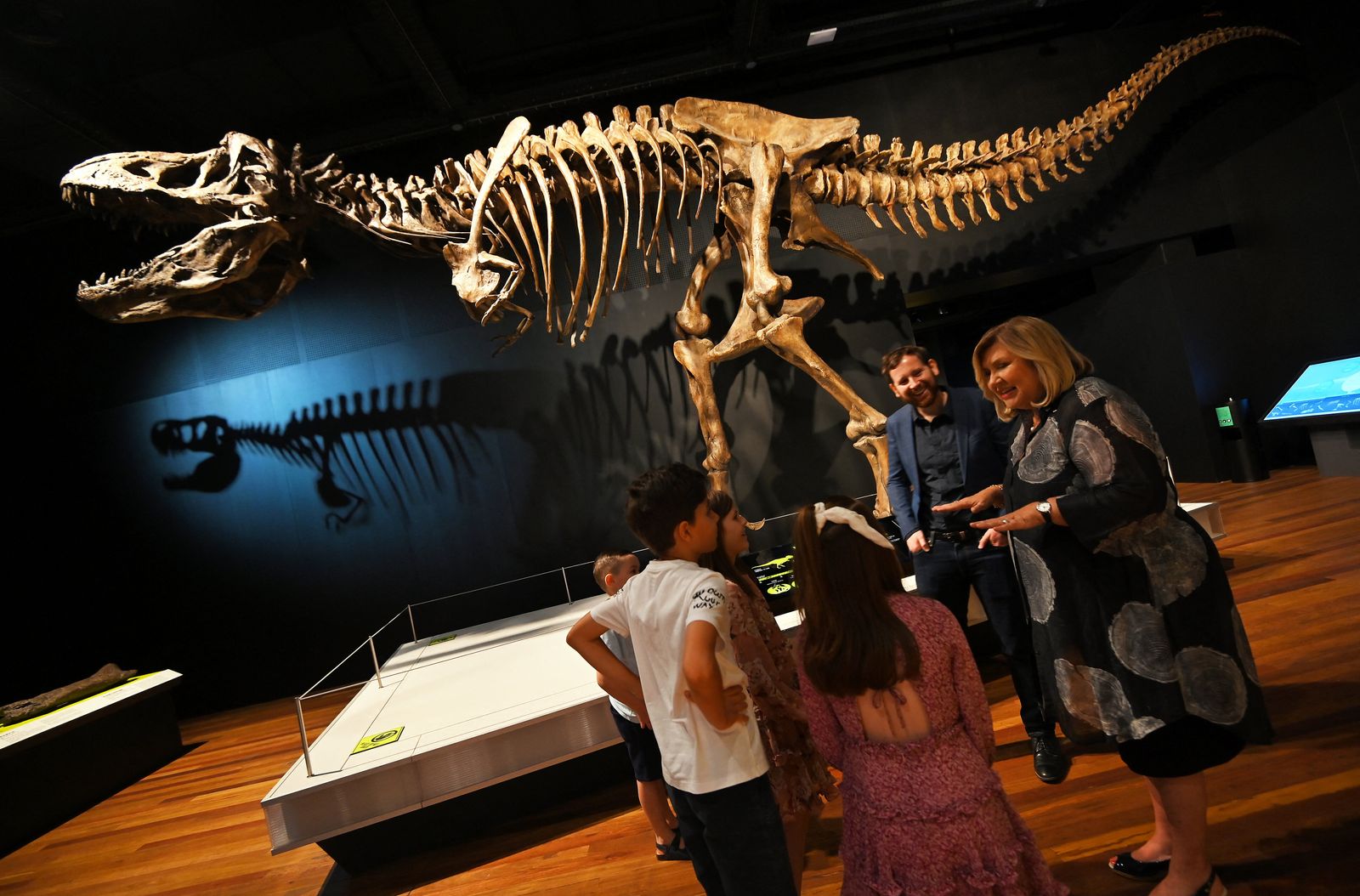 Director and CEO of the Australian Museum Kim McKay speaks to children in the Tyrannosaurs exhibit during the reopening of the Australian Museum in Sydney on November 26, 2020. (Photo by Steven SAPHORE / AFP) - AFP