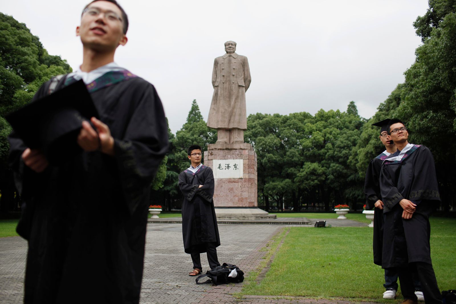 خريجون في جامعة فودان بشنغهاي ياتقطون صورة أمام تمثال للزعيم الصيني الراحل ماو تسي تونغ - 28 يونيو 2013 - REUTERS