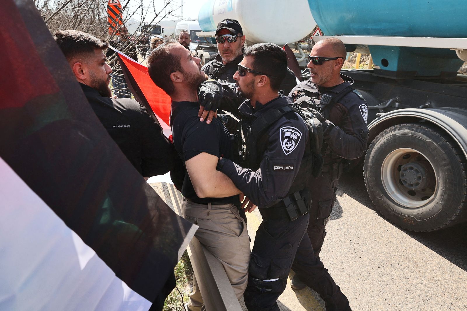 - أحد أفراد قوات الأمن الإسرائيلية يشتبك مع متظاهر خلال احتجاجات لنشطاء سلام فلسطينيين وإسرائيليين عند مدخل حوارة. 3 مارس 2023 - AFP