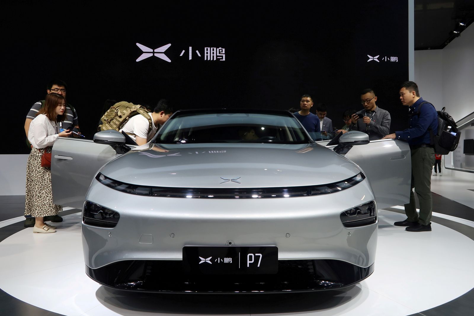 FILE PHOTO: People look at XPeng's P7 sedan model displayed at the Guangzhou auto show in Guangzhou - REUTERS