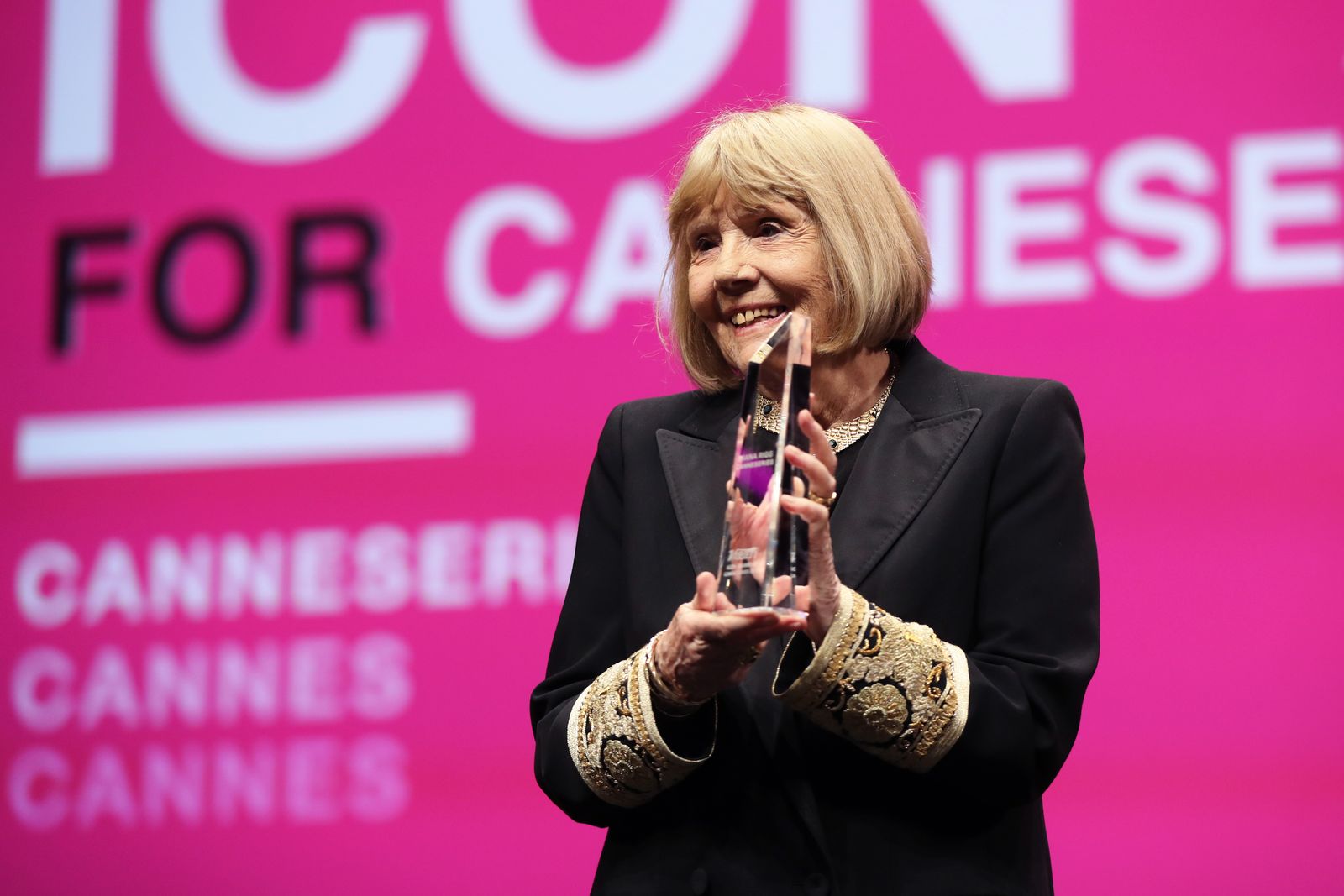 ديانا ريغ تقف بعد حصولها على جائزة الأيقونة خلال حفل افتتاح الدورة الثانية لمهرجان كان الدولي لسلسلة (كان). 5 أبريل 2019  - AFP