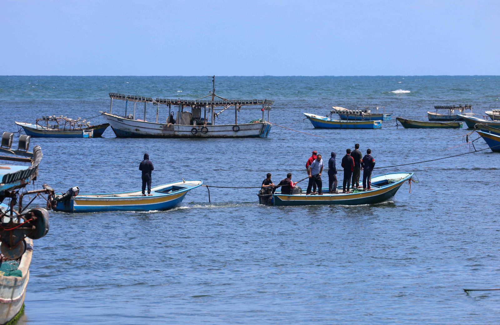 Palestinian fishermen set to sea on their boats after a ban on fishing was lifted, at the main port in Gaza City on May 22, 2021, following a ceasefire between Israel and Palestinian militants in the Israeli-blockaded enclave. - As the ceasefire holds, humanitarian aid began to enter the enclave ravaged by 11 days of bloodshed. While thousands of displaced Palestinians returned to their homes, and Israelis began to resume normal life a day earlier, international focus turned to the reconstruction of the bomb-shattered Gaza Strip. (Photo by Emmanuel DUNAND / AFP) - AFP