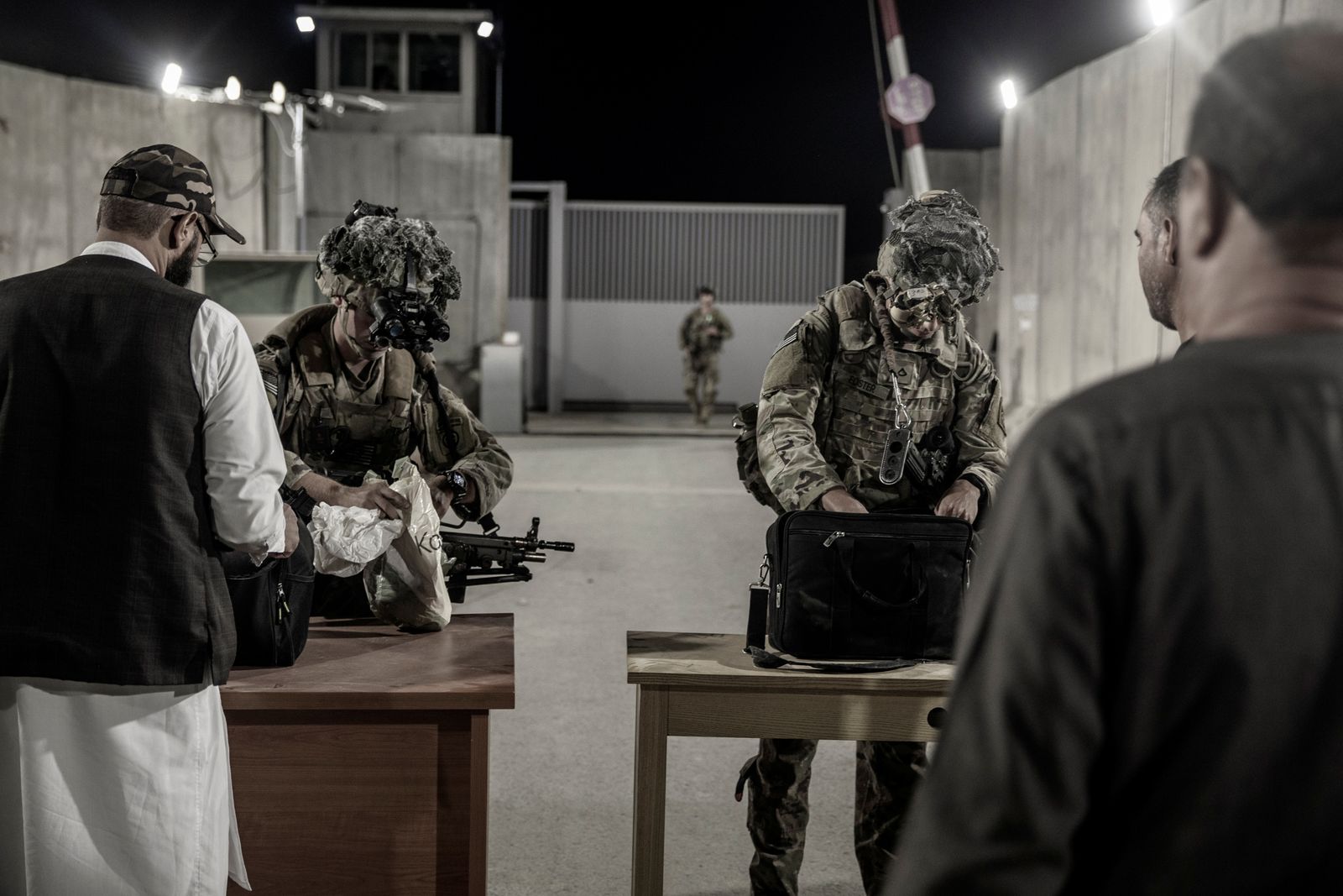 جنديان أميركيان يفتشان أمتعة الأفغان قبل الدخول إلى مطار كابول للإجلاء. 25 أغسطس 2021 - REUTERS