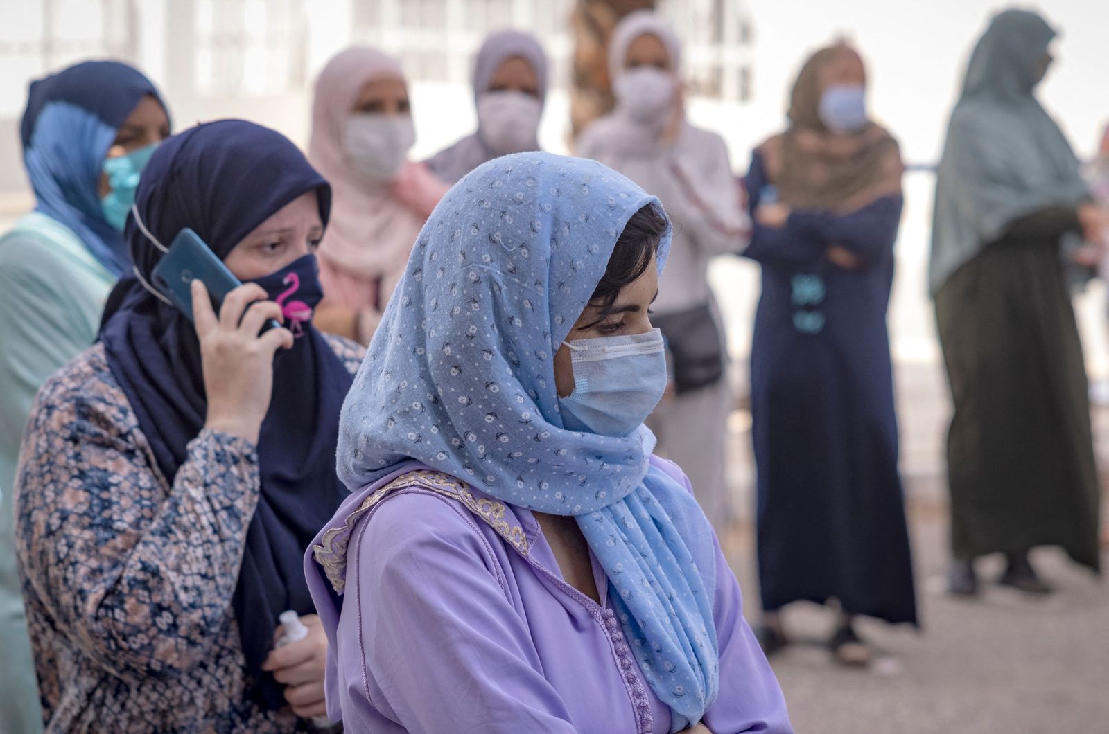 Moroccans wait for their turn outside a Covid-19 vaccination centre, part of the local 