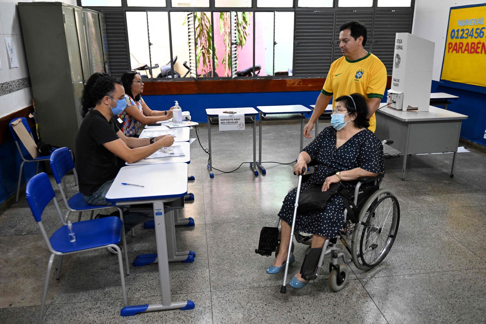 A woman on wheelchair votes at a polling station in Brasilia, on October 30, 2022, during the presidential run-off election. - After a bitterly divisive campaign and inconclusive first-round vote, Brazil elects its next president in a cliffhanger runoff between far-right incumbent Jair Bolsonaro and veteran leftist Luiz Inacio Lula da Silva. (Photo by EVARISTO SA / AFP) - AFP