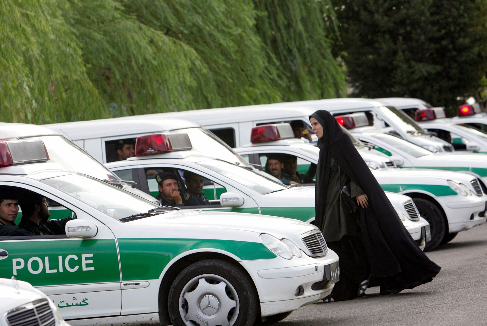 تظهر هذه الصورة التي التقطت في 23 يوليو 2007 شرطية إيرانية تسير بين سيارات 