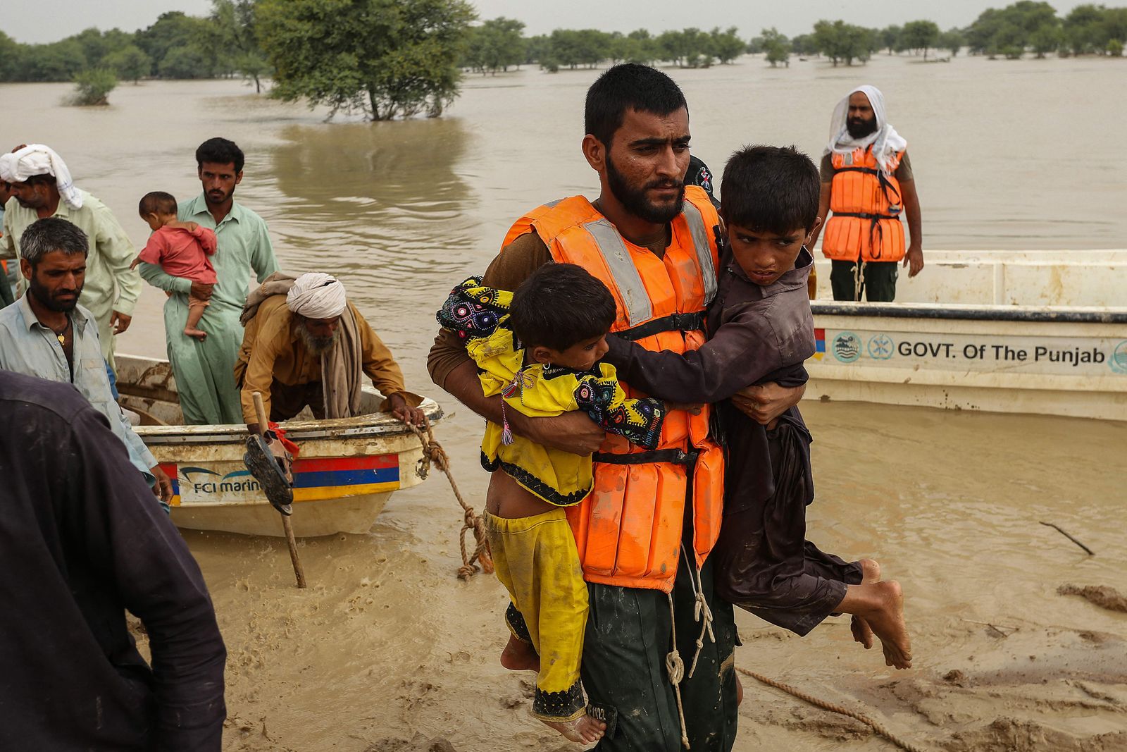 عمال إنقاذ يساعدون في إخلاء سكان من منازلهم المنازل المتضررة جراء الفيضانات بمقاطعة البنجاب- 27 أغسطس 2022 - AFP