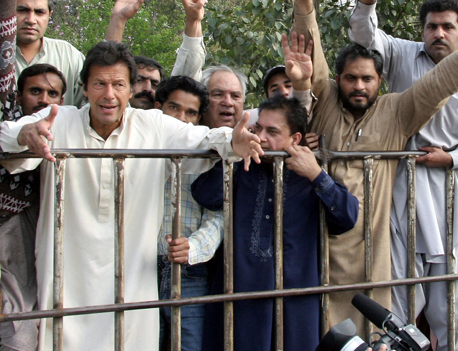 عمران خان يقف مع مؤيديه بعد أن اعتقلته الشرطة خلال مظاهرة في لاهور - 26 فبراير 2006 - AFP