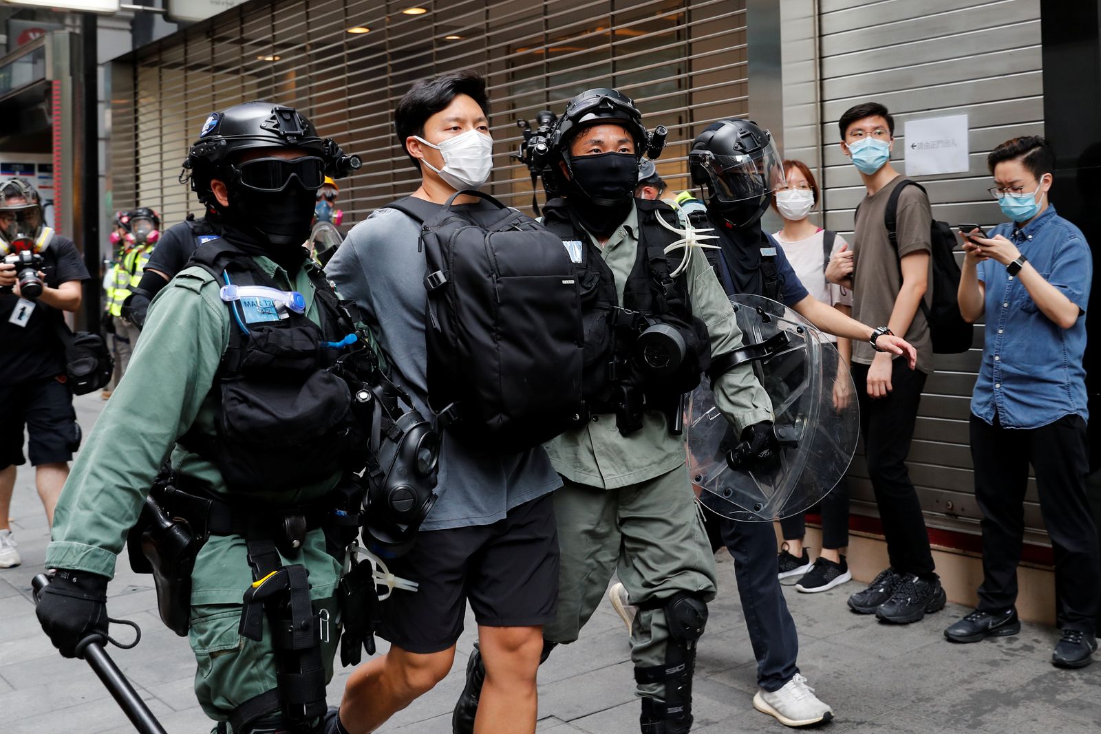 ضباط شرطة يحتجزون متظاهراً شارك في إحدى الاحتجاجات في هونغ كونغ - REUTERS
