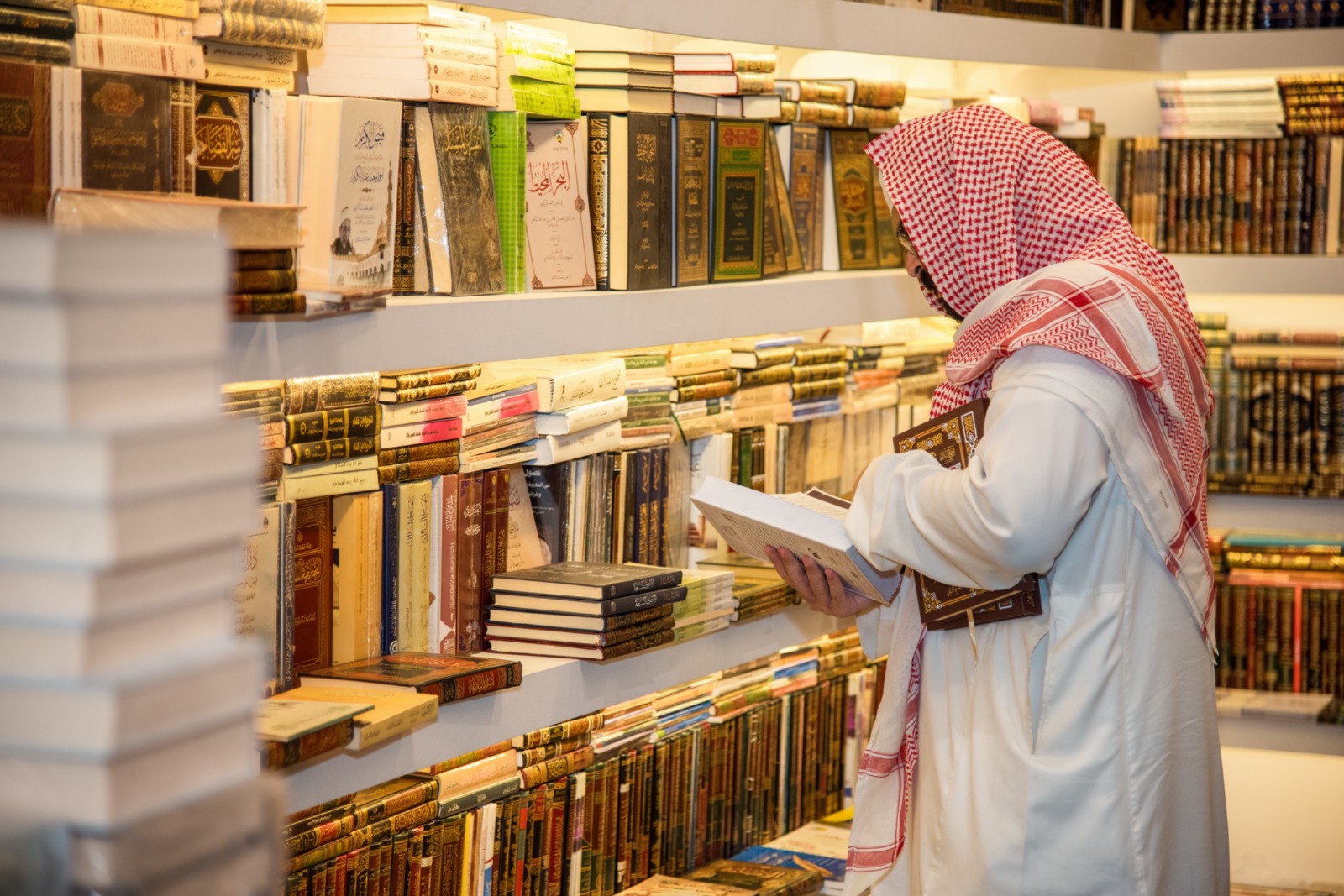 زائر يتصفح الكتب في معرض المدينة المنورة للكتاب 2025