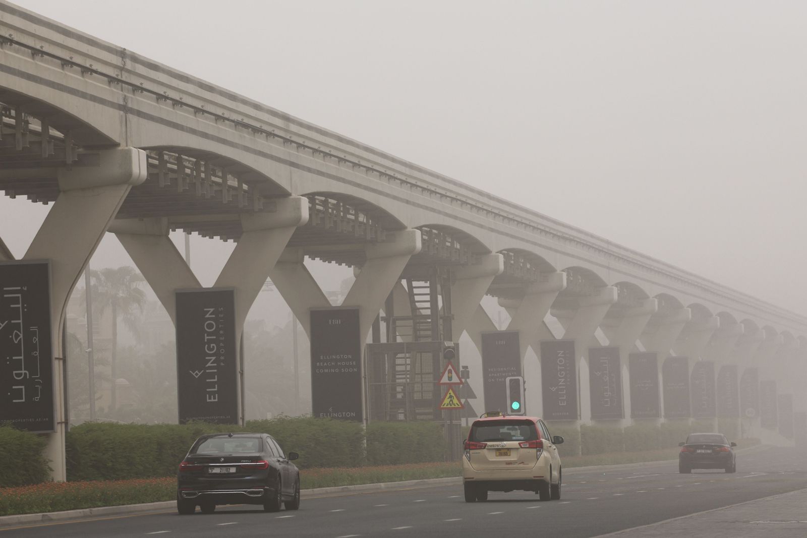 Cars drive along a boulevard during a sand storm in the Gulf emirate of Dubai, on August 14, 2022. (Photo by Giuseppe CACACE / AFP) - AFP