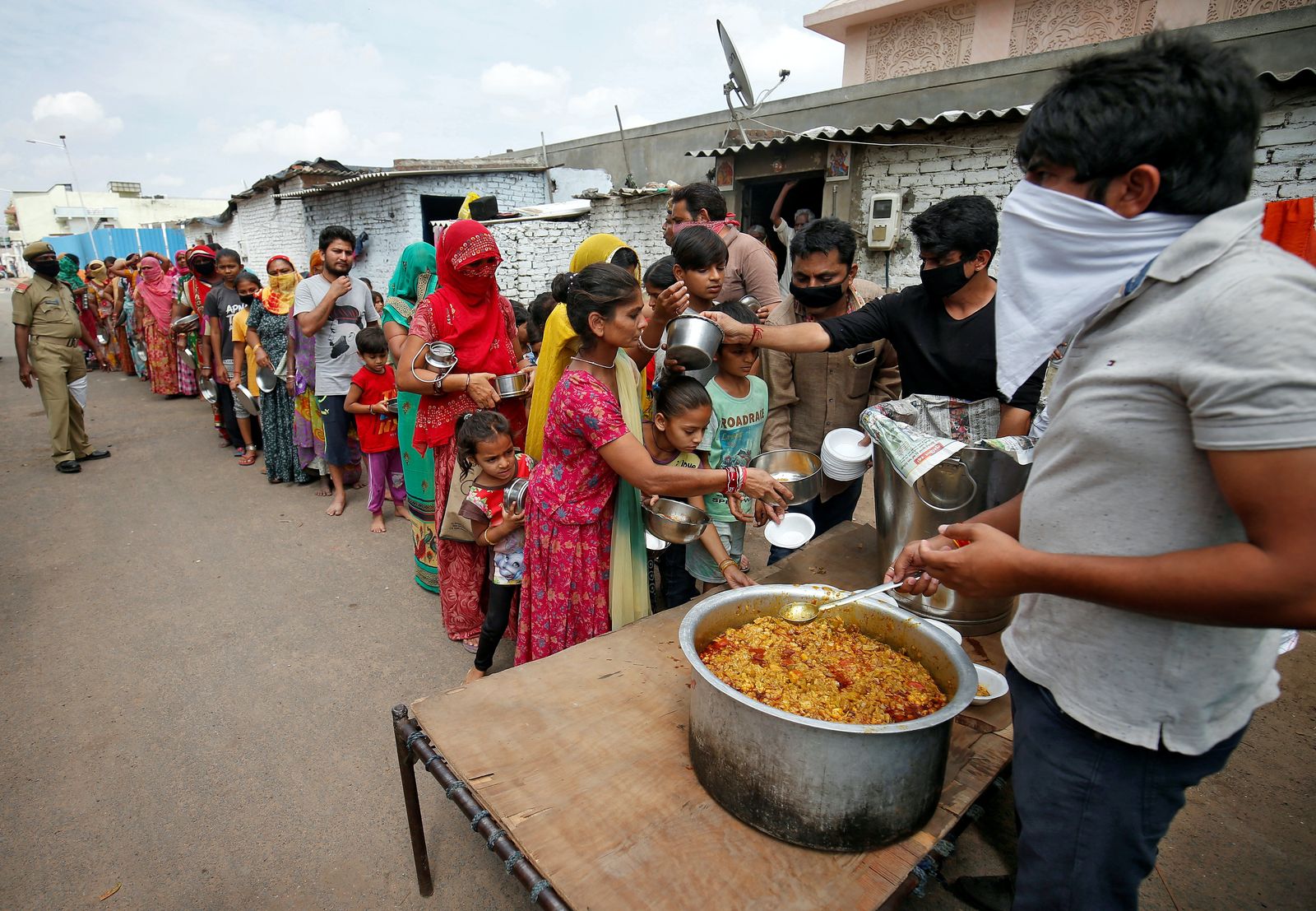 توزيع طعام مجاني على سكان أحياء فقيرة في مدينة أحمد آباد الهندية - 27 مارس 2020 - REUTERS