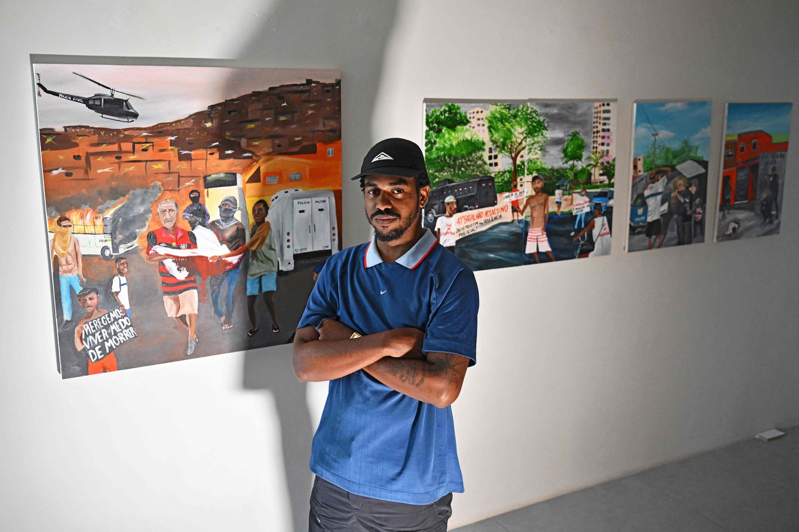 Brazilian artist Johny Alexandre Gomes, known as Jota, 22, poses for a picture next to his artwork at his studio in Rio de Janeiro, Brazil on April 6, 2023. - A new generation of young black artists from Rio de Janeiro's poor neighborhoods is gaining prominence at contemporary art fairs and prestigious museums. (Photo by CARL DE SOUZA / AFP) - AFP