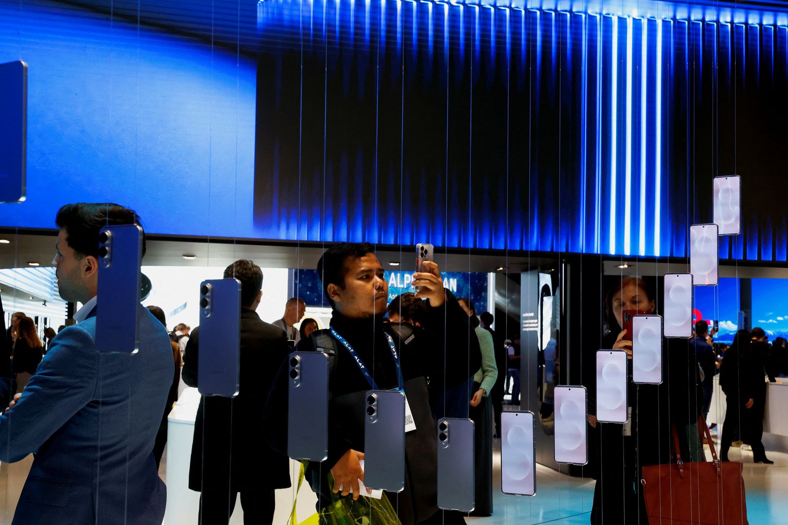 A man takes a picture of a prototype of the not-yet-released Samsung Galaxy S25 Edge, exhibited at the Samsung venue at the Mobile World Congress trade show in Barcelona, Spain, March 3, 2025. REUTERS/Bruna Casas