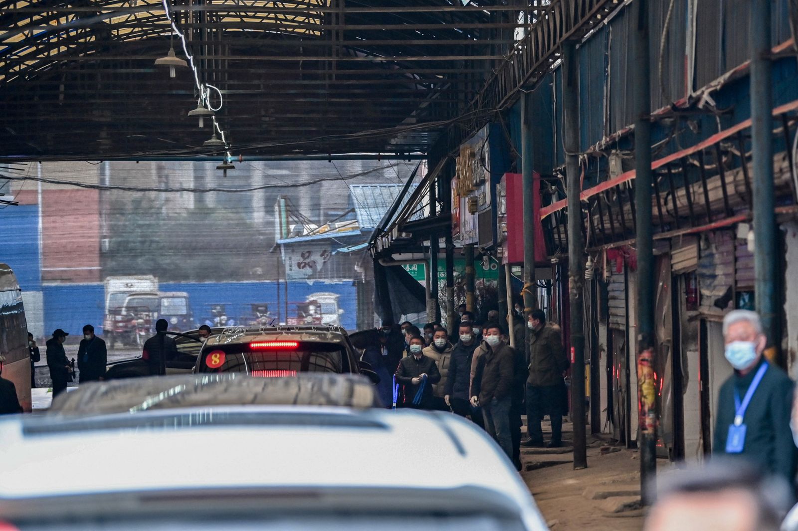 أعضاء فريق التحقيق الأممي يصلون بسياراتهم إلى سوق هوانان المغلق في ووهان - 31 يناير 2021 - AFP
