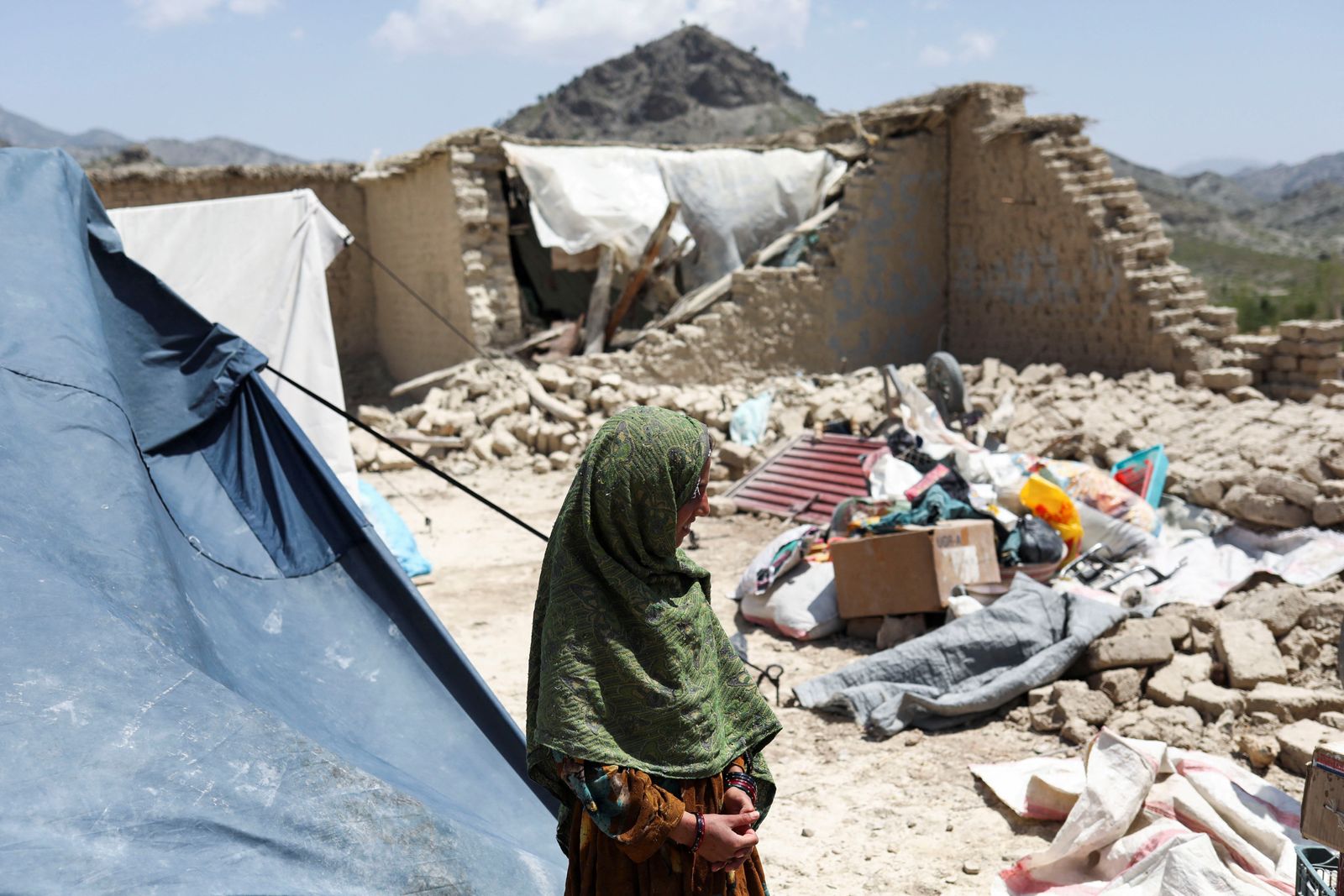 An Afghan girl stands near her house that was damaged by an earthquake in Kalizei village in the Gayan district of Paktika province - REUTERS
