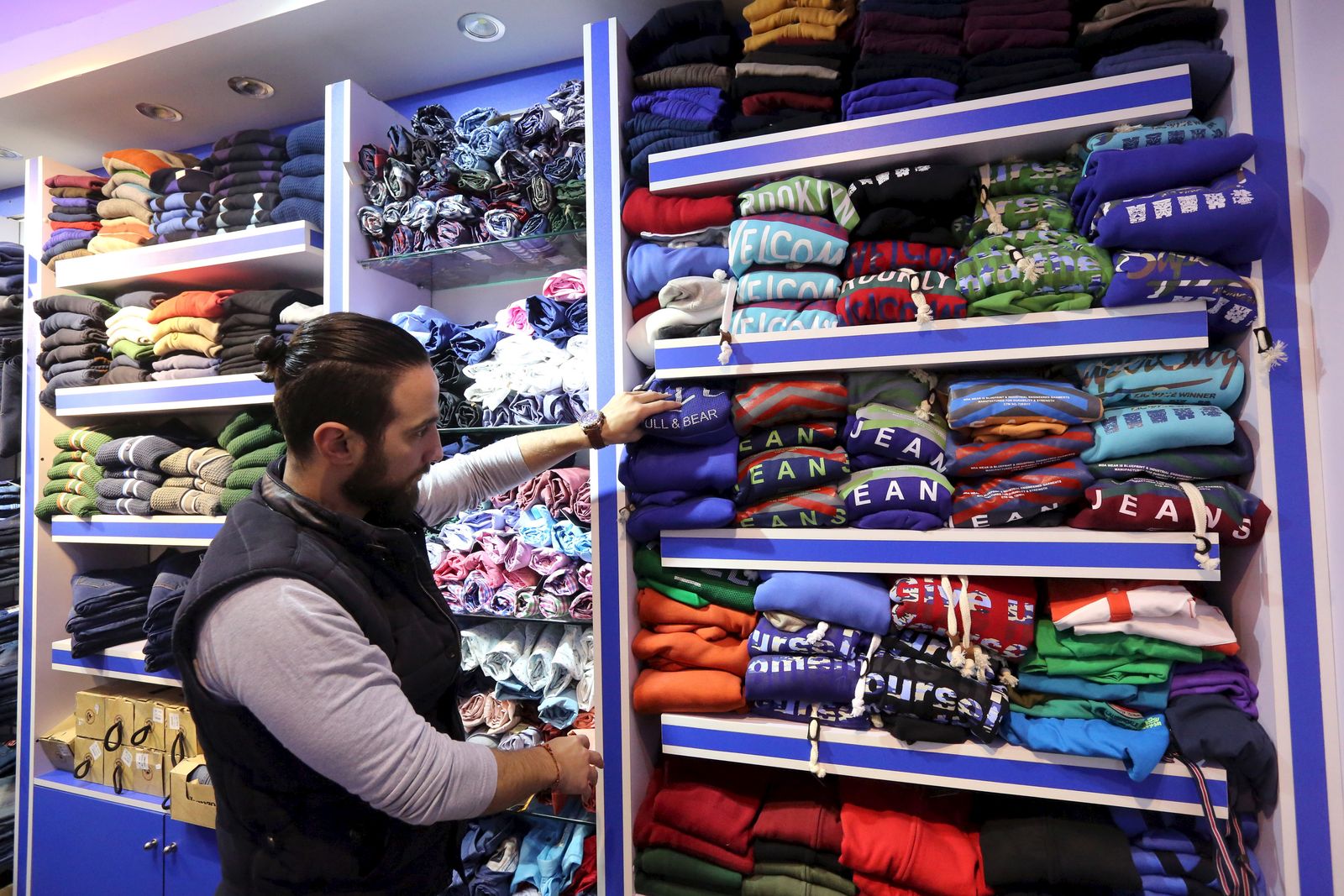 A Syrian man works at a clothes shop in an area called 6 October City in Giza - REUTERS