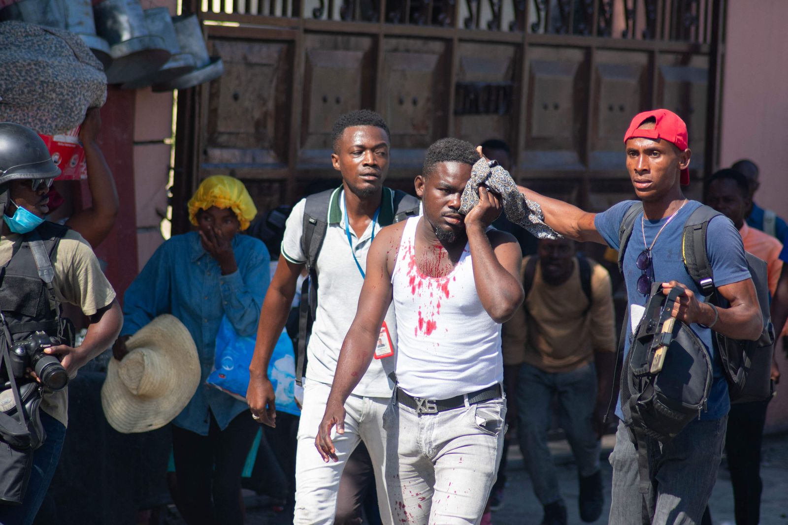 An ijured journalist is helped after he was reportedly hit by a tear gas canister fired by police in Port-au-Prince, Haiti, on March 9, 2024. Sporadic gunfire rang out in Port-au-Prince late March 8, an AFP correspondent there heard, as residents desperately sought shelter amid the recent explosion of gang violence in the Haitian capital. (Photo by Clarens SIFFROY / AFP)