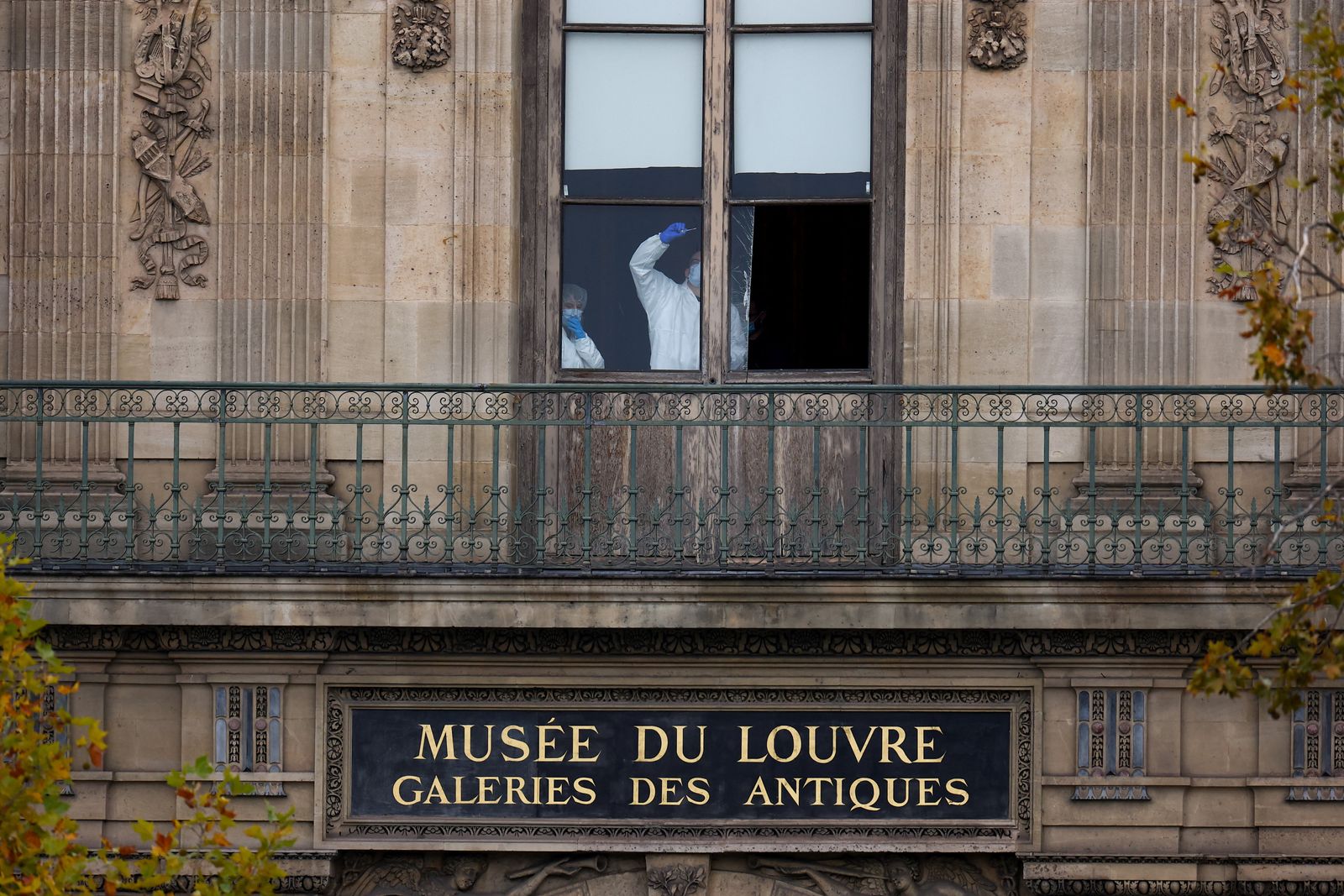 Members of a forensic team inspect a window believed to have been used in what the French Interior Ministry said was a robbery at the Louvre museum during which jewellery was stolen, in Paris, France, October 19, 2025. REUTERS/Gonzalo Fuentes