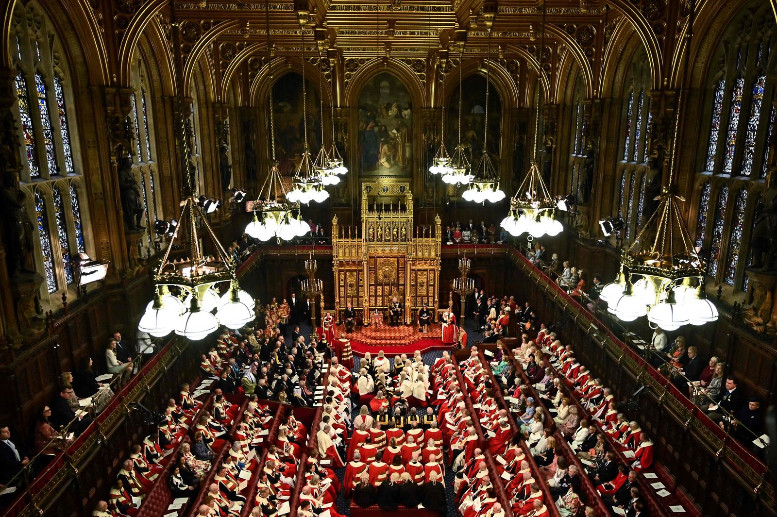 Britain's Prince Charles, Prince of Wales  (2nd R) reads the Queen's Speech as he sits by the Imperial State Crown (2nd L), Britain's Camilla, Duchess of Cornwall (R) and Britain's Prince William, Duke of Cambridge (L) in the House of Lords chamber, during the State Opening of Parliament, at the Houses of Parliament, in London, on May 10, 2022. - The 96-year-old monarch, who usually presides over the pomp-filled event and reads out her government's legislative programme from a gilded throne in the House of Lords, will skip the annual showpiece on her doctors' advice. (Photo by Ben STANSALL / various sources / AFP) - AFP
