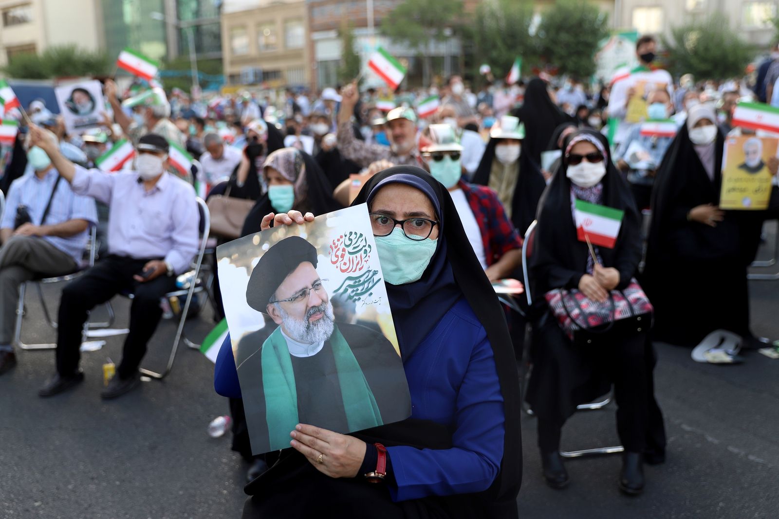 أنصار إبراهيم رئيسي يحملون ملصقات له خلال تجمع انتخابي في طهران - 16 يونيو 2021 - via REUTERS