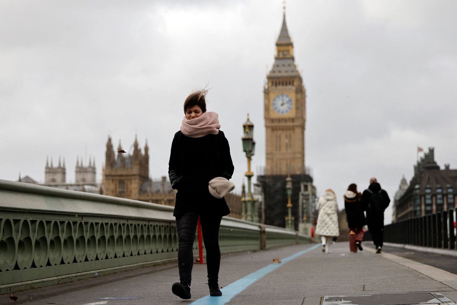 الرياح تعصف بالسائرين على جسر وستمنستر، بالقرب من مجلسي البرلمان في وسط لندن. 18 فبراير 2022 - AFP