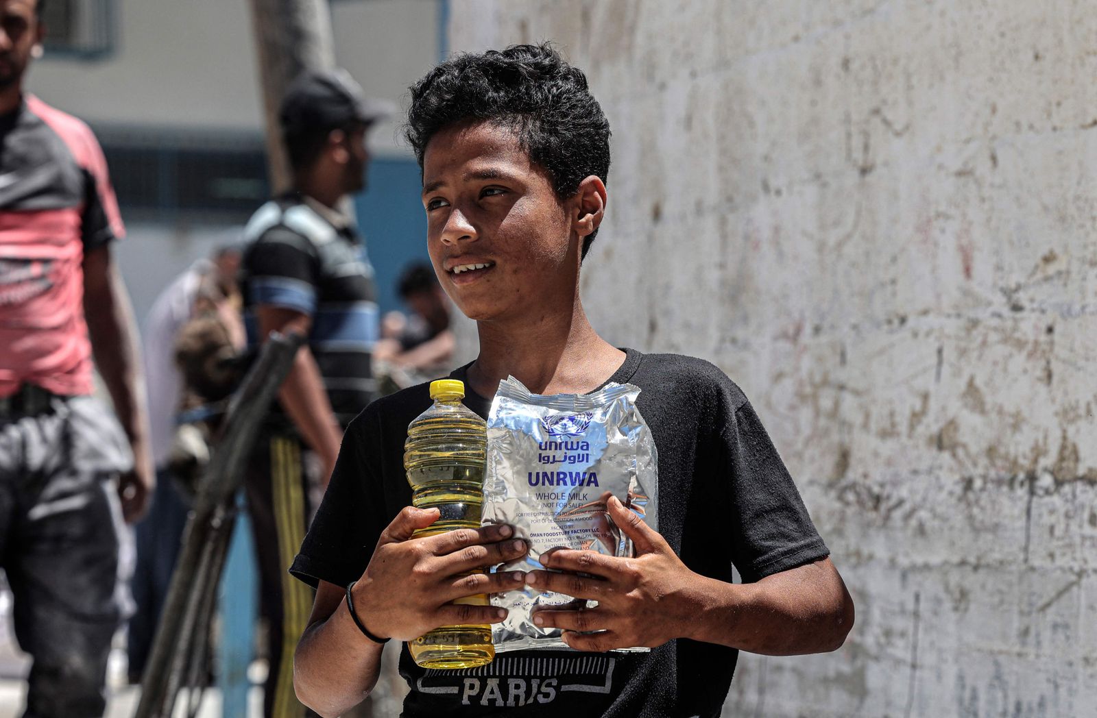 Palestinians receive their monthly food rations from the United Nations Relief and Works Agency (UNRWA) warehouse in Khan Younis in the southern Gaza Strip on June 14, 2022. (Photo by SAID KHATIB / AFP) - AFP