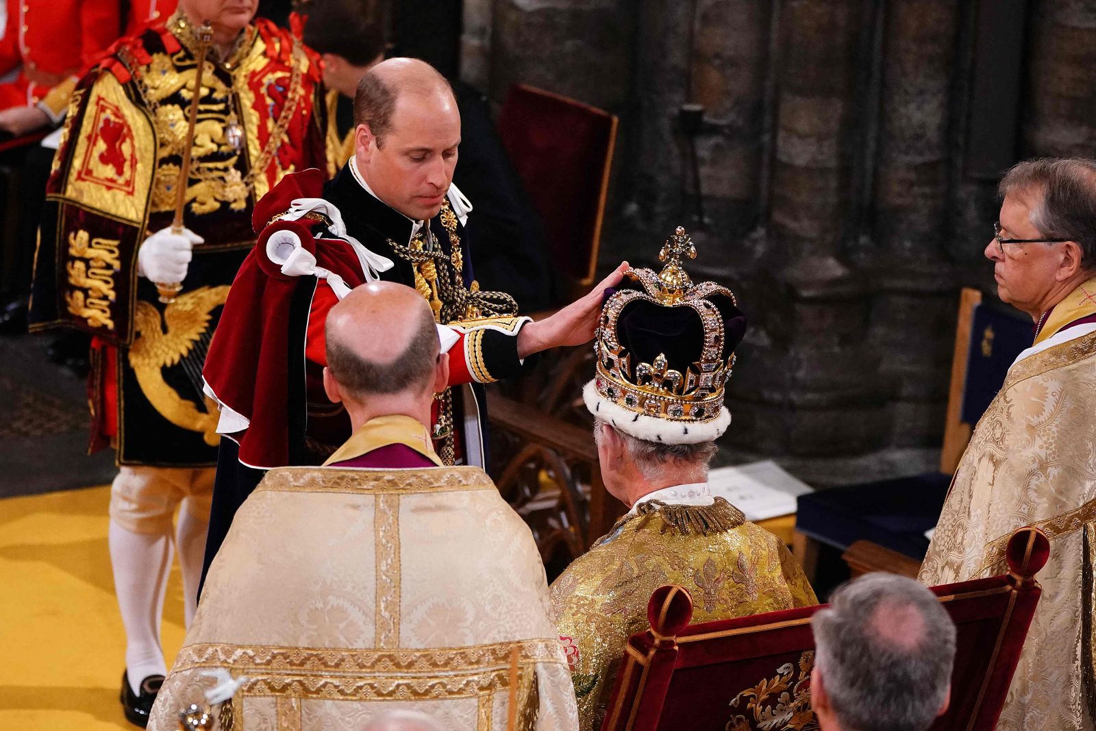 Britain's Prince William, Prince of Wales touches St Edward's Crown on the head of his father, Britain's King Charles III, during the King's Coronation Ceremony inside Westminster Abbey in central London on May 6, 2023. - The set-piece coronation is the first in Britain in 70 years, and only the second in history to be televised. Charles will be the 40th reigning monarch to be crowned at the central London church since King William I in 1066. Outside the UK, he is also king of 14 other Commonwealth countries, including Australia, Canada and New Zealand. Camilla, his second wife, will be crowned queen alongside him and be known as Queen Camilla after the ceremony. (Photo by Yui Mok / POOL / AFP) - AFP