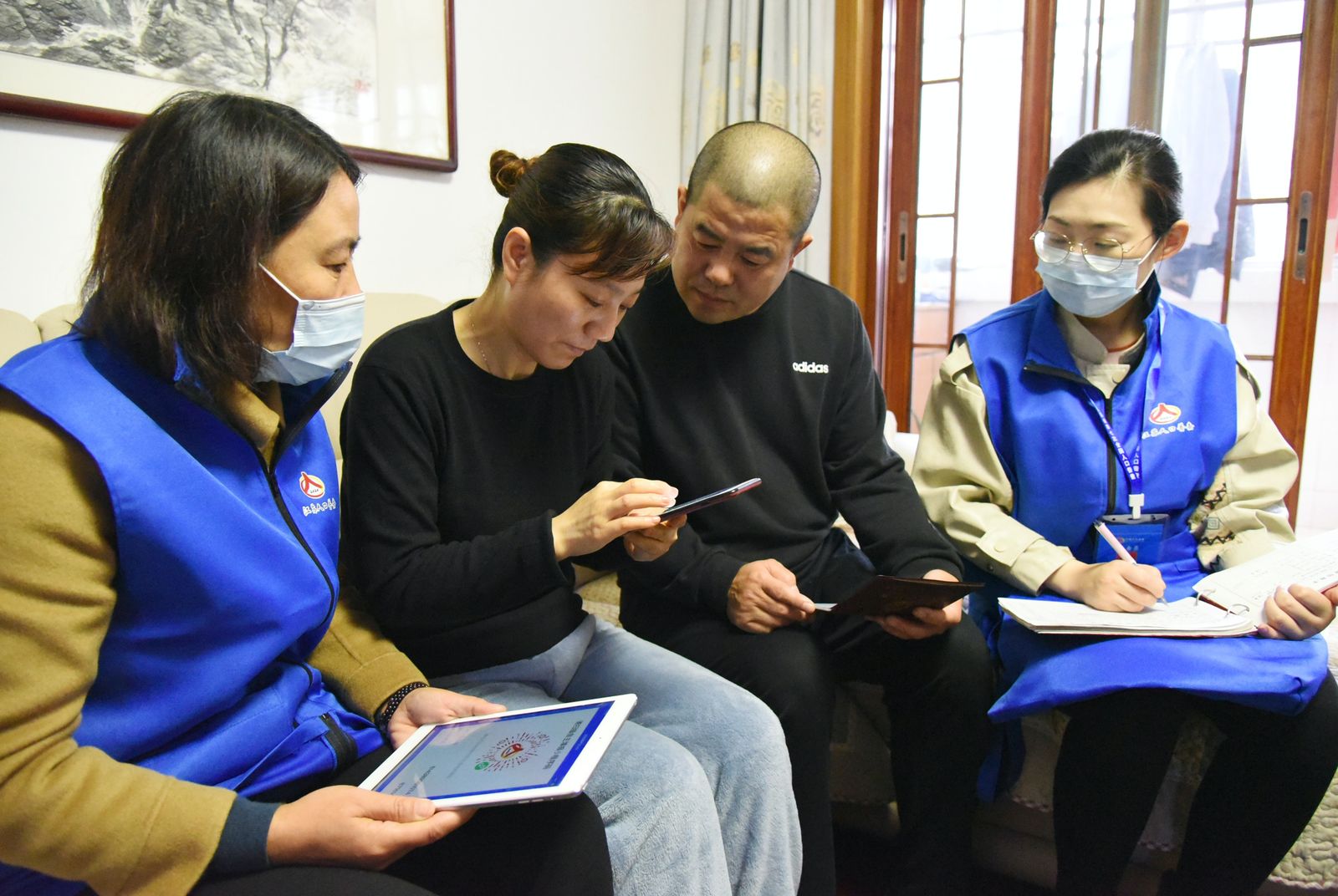 موظفو التعداد السكاني يجمعون معلومات من أحد سكان مدينة يانيونغانغ في الصين 1 نوفمبر 2020  - AFP