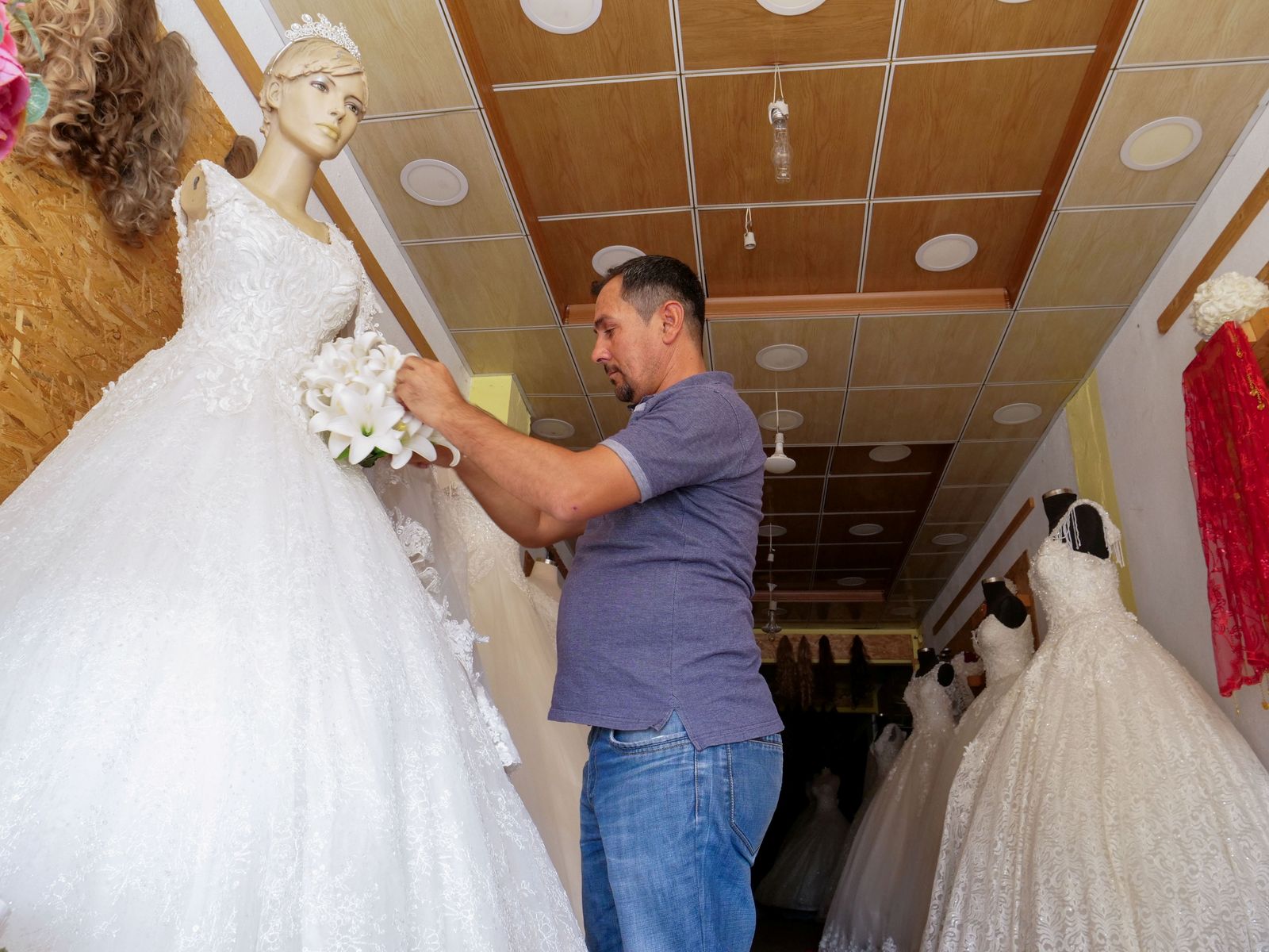 Aziz Abdullah, who wishes to leave the town with his family, works in his wedding dress shop in the town of Shiladze - REUTERS