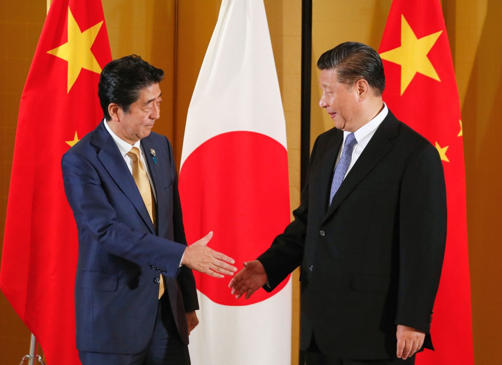الرئيس الصيني شي جينبينغ ورئيس الوزراء الياباني شينزو آبي يتصافحان قبل قمة مجموعة العشرين في أوساكا - 27 يونيو  2019 - Bloomberg