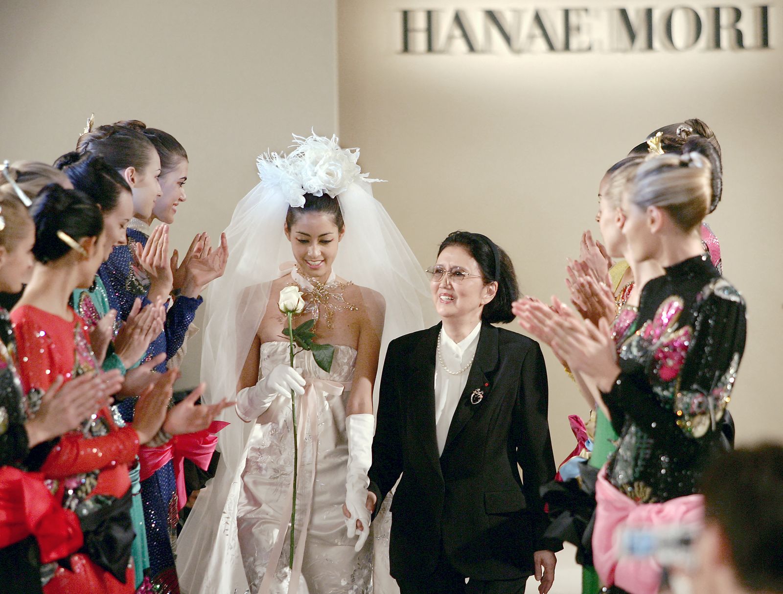 Hanae Mori (وسط) تسير على مسرح العرض بعد تقديم مجموعة الأزياء الراقية لخريف وشتاء 2004-2005 في العاصمة الفرنسية باريس - 7 يوليو 2004 - AFP