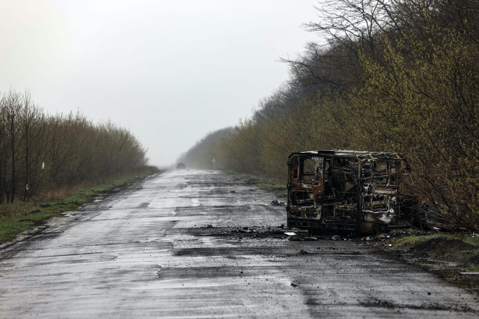 حافلة محترقة على طريق خالٍ في مدينة بوباسنا بإقليم دونباس شرقي أوكرانيا - AFP