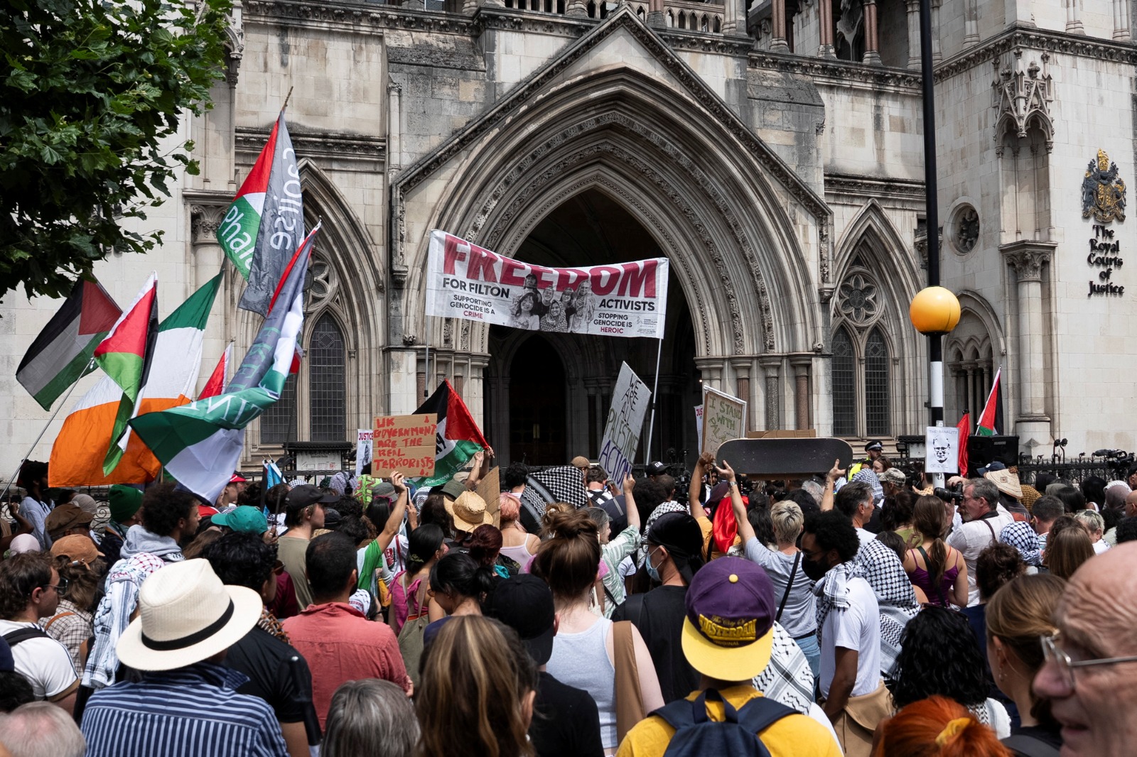 أنصار حملة 'فلسطين أكشن' المؤيدة للقضية الفلسطينية يرفعون لافتات خارج المحكمة البريطانية العليا في العاصمة لندن- 4 يوليو 2025
