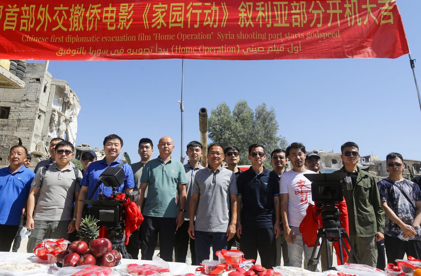 Chinese Ambassador To Syria Feng Biao (C) poses for a picture with the cast and crew in the Hajar al-Aswad neighbourhood of the Syrian capital Damascus on July 14, 2022, during the filming of a scene in a film titled 
