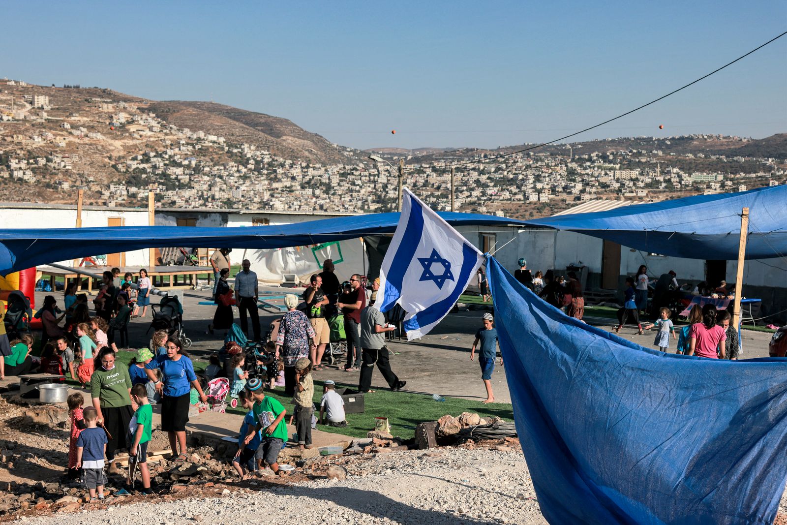 مستوطنون إسرائيليون يتجمعون في البؤرة الاستيطانية إفيتار بالقرب من مدينة نابلس في الضفة الغربية المحتلة، 1 يوليو 2021