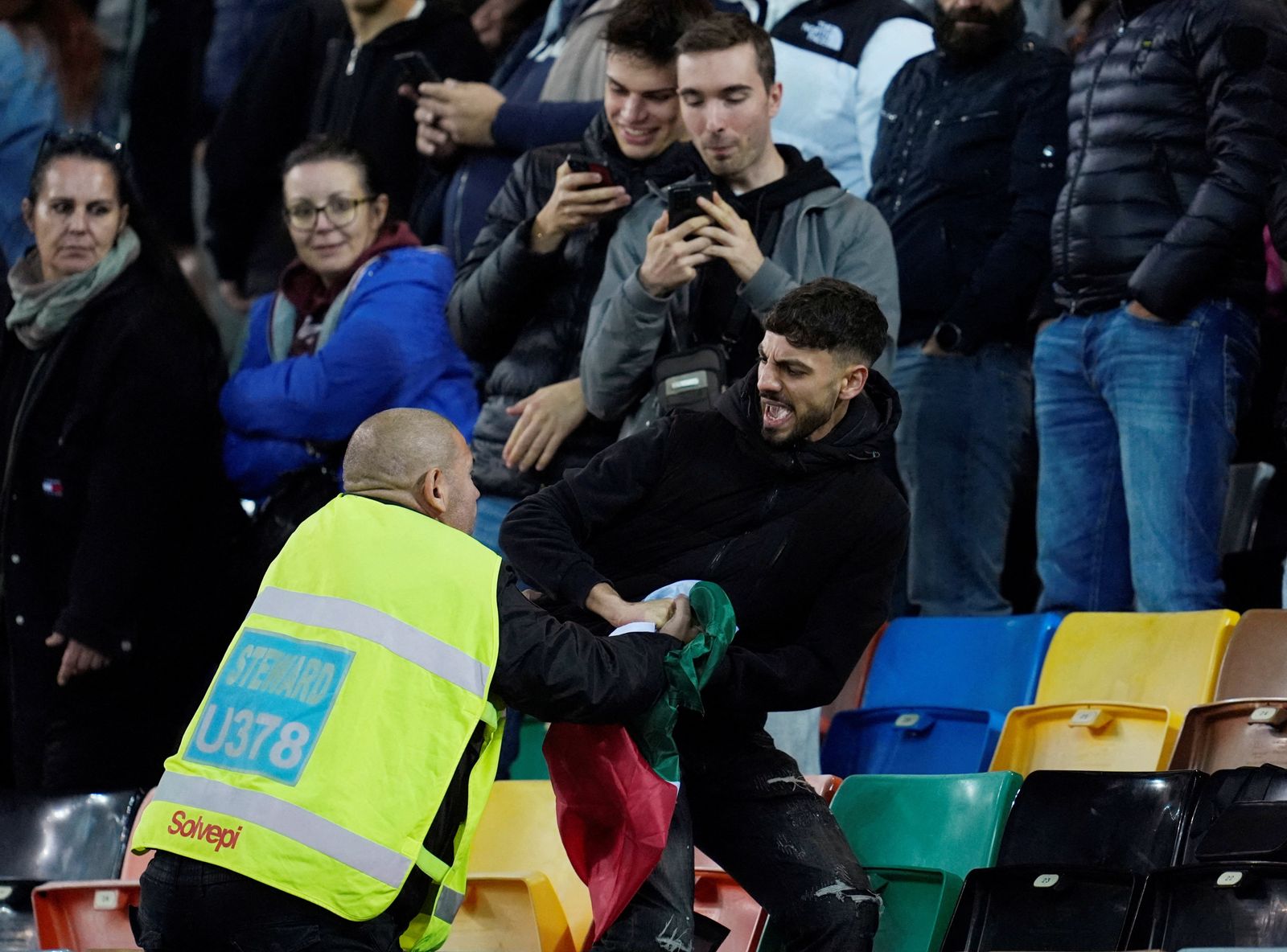 Soccer Football - FIFA World Cup - UEFA Qualifiers - Group I - Italy v Israel - Bluenergy Stadium, Udine, Italy - October 14, 2025 A steward removes a Palestinian flag from a fan in the stands. REUTERS/Matteo Ciambelli