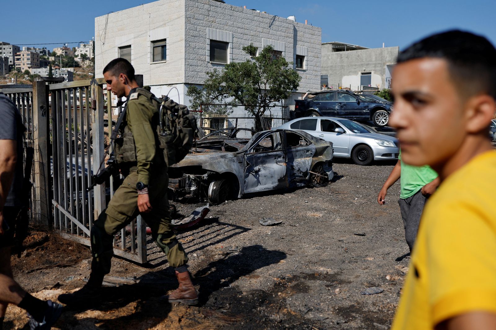 جندي إسرائيلي يقف أمام منزل فلسطيني تعرض لهجوم مستوطنين بالقرب من رام الله في الضفة الغربية المحتلة. 21 يونيو 2023