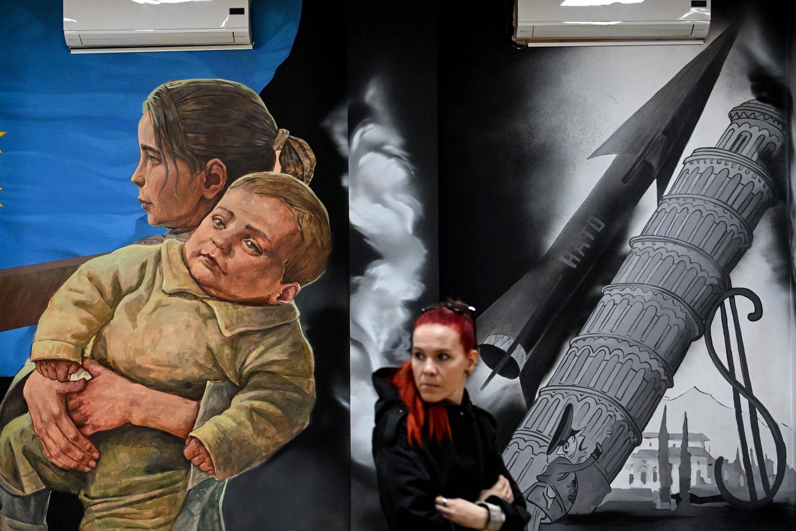 A woman looks at paintings at the exhibition 