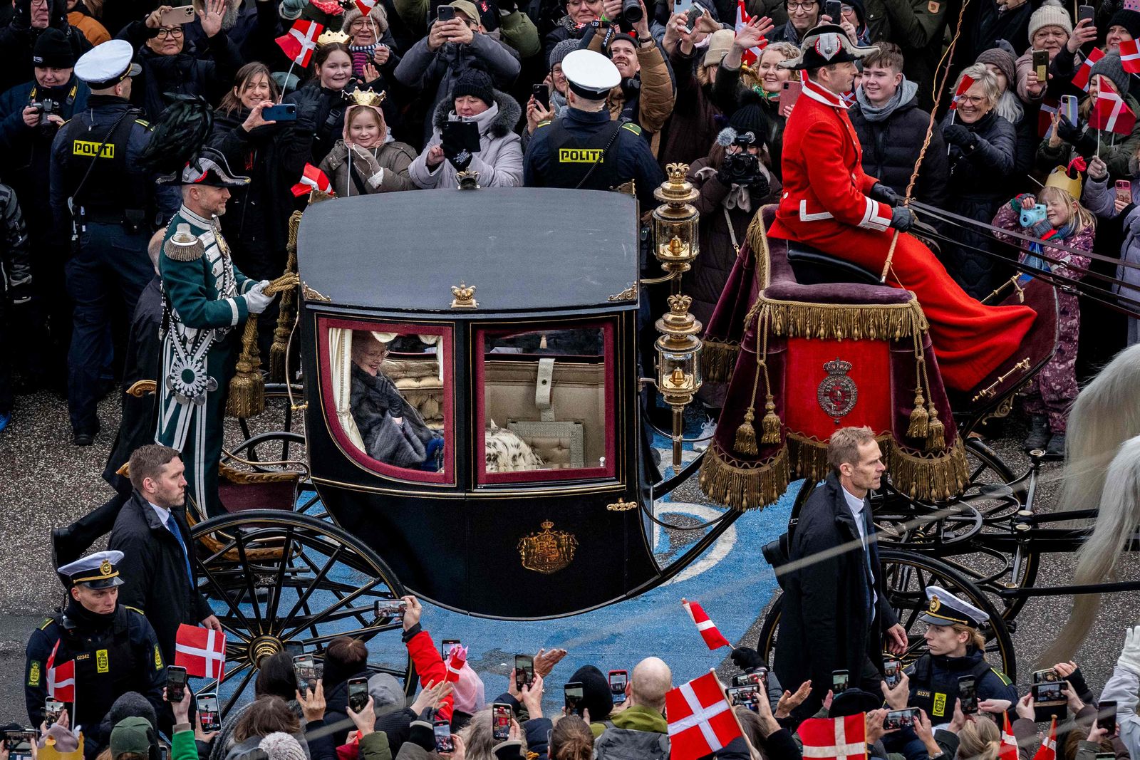 Queen Margrethe II of Denmark is seen as she rides in a carriage escorted by the Guard Hussar Regiment's Mounted Squadron from Amalienborg Castle to Christiansborg Castle for her proclamation of abdication in Copenhagen, Denmark, on January 14, 2024. Denmark turns a page in its history on January 14 when Queen Margrethe abdicates and her son becomes King Frederik X, with more than 100,000 Danes expected to turn out for the unprecedented event. (Photo by Ida Marie Odgaard / Ritzau Scanpix / AFP) / Denmark OUT