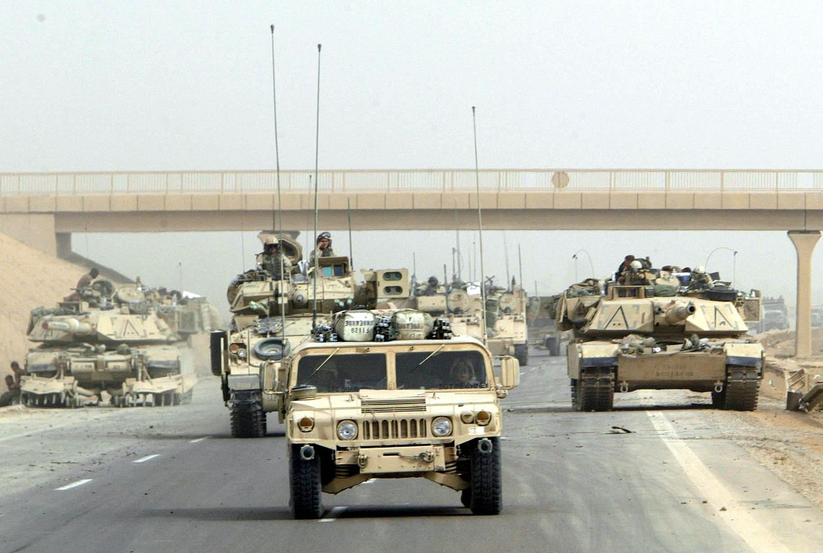مركبات تابعة للجيش الأميركي خلال تأمينها طريقاً سريعاً باتجاه مطار بغداد الدولي، 6 أبريل 2003 - REUTERS