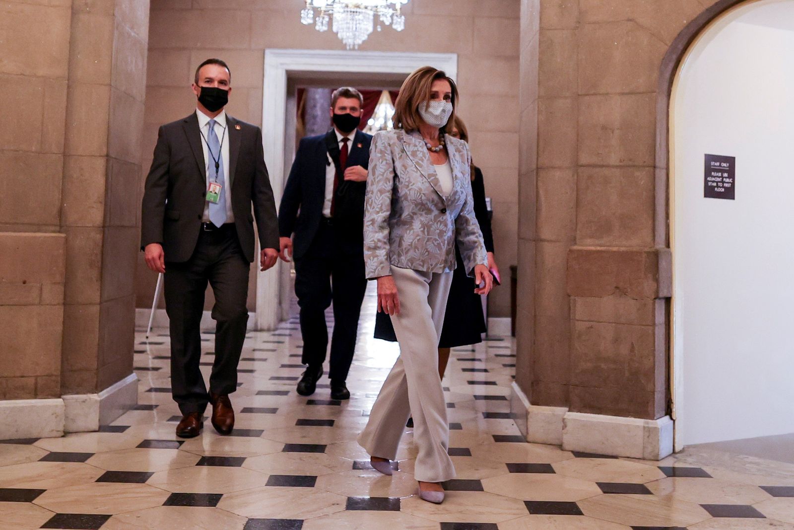 رئيسة مجلس النواب الأميركي نانسي بيلوسي متوجهة إلى مكتبها مبنى الكونغرس وسط عناصر تأمينها، 3 يناير 2021 - REUTERS