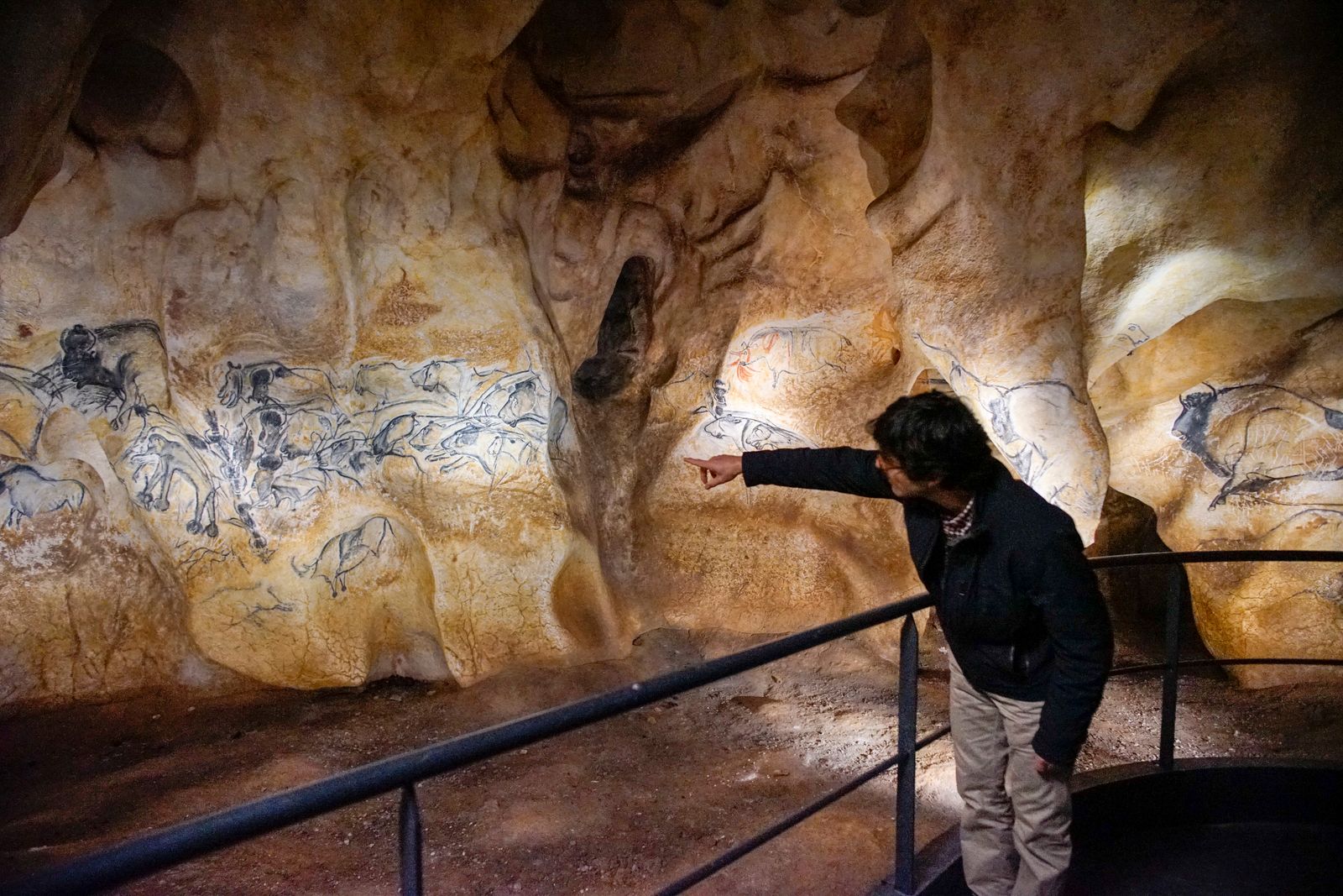 زائر ينظر إلى نسخة طبق الأصل من رسومات حيوانات ما قبل التاريخ شوهدت على الحائط خلال زيارة لموقع مشروع كهف 